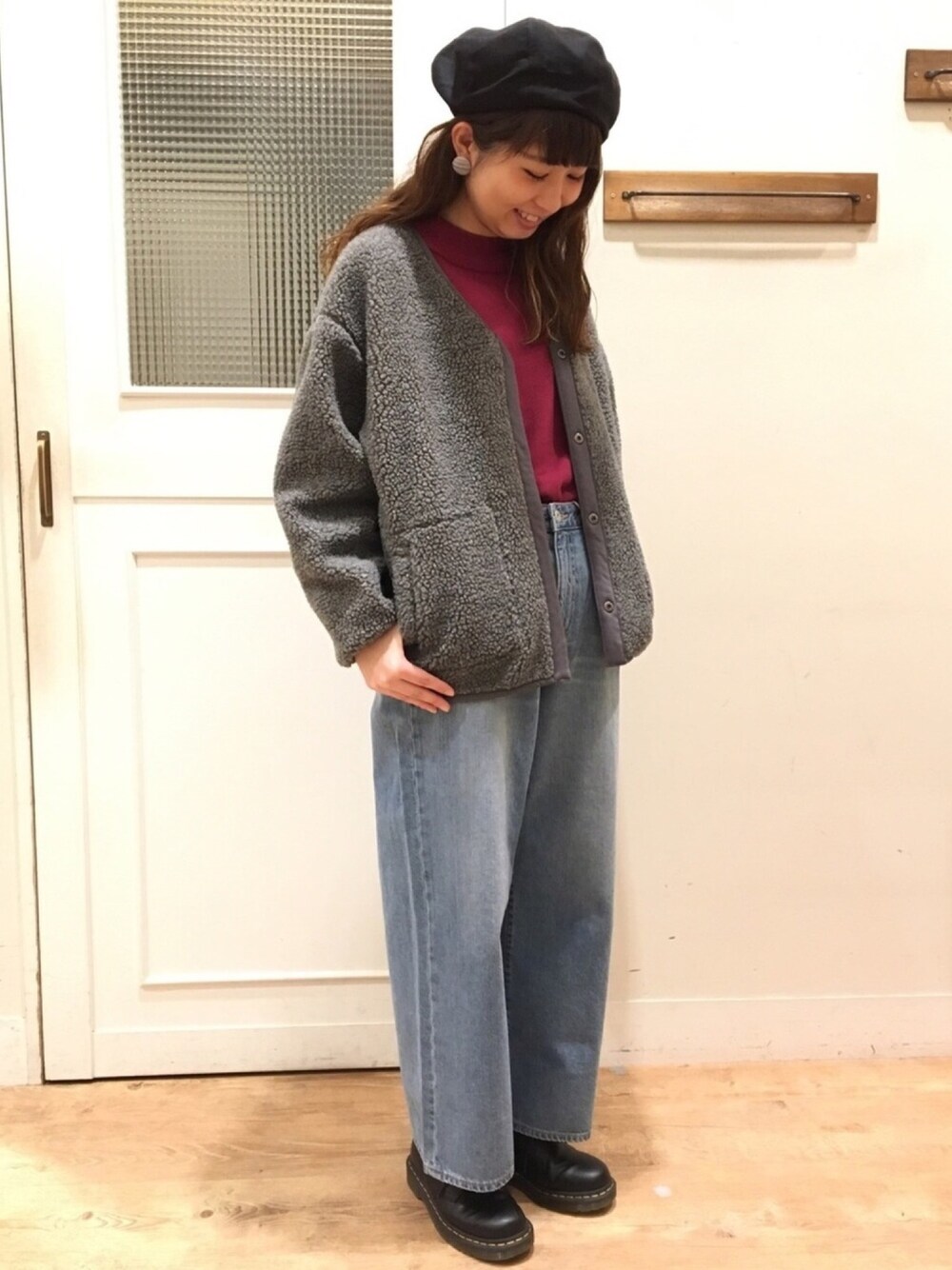 グレー系のブルゾン、パープル系のニット/セーター、ブルー系のデニムパンツを着用したレディースの冬コーディネートの1枚目の写真