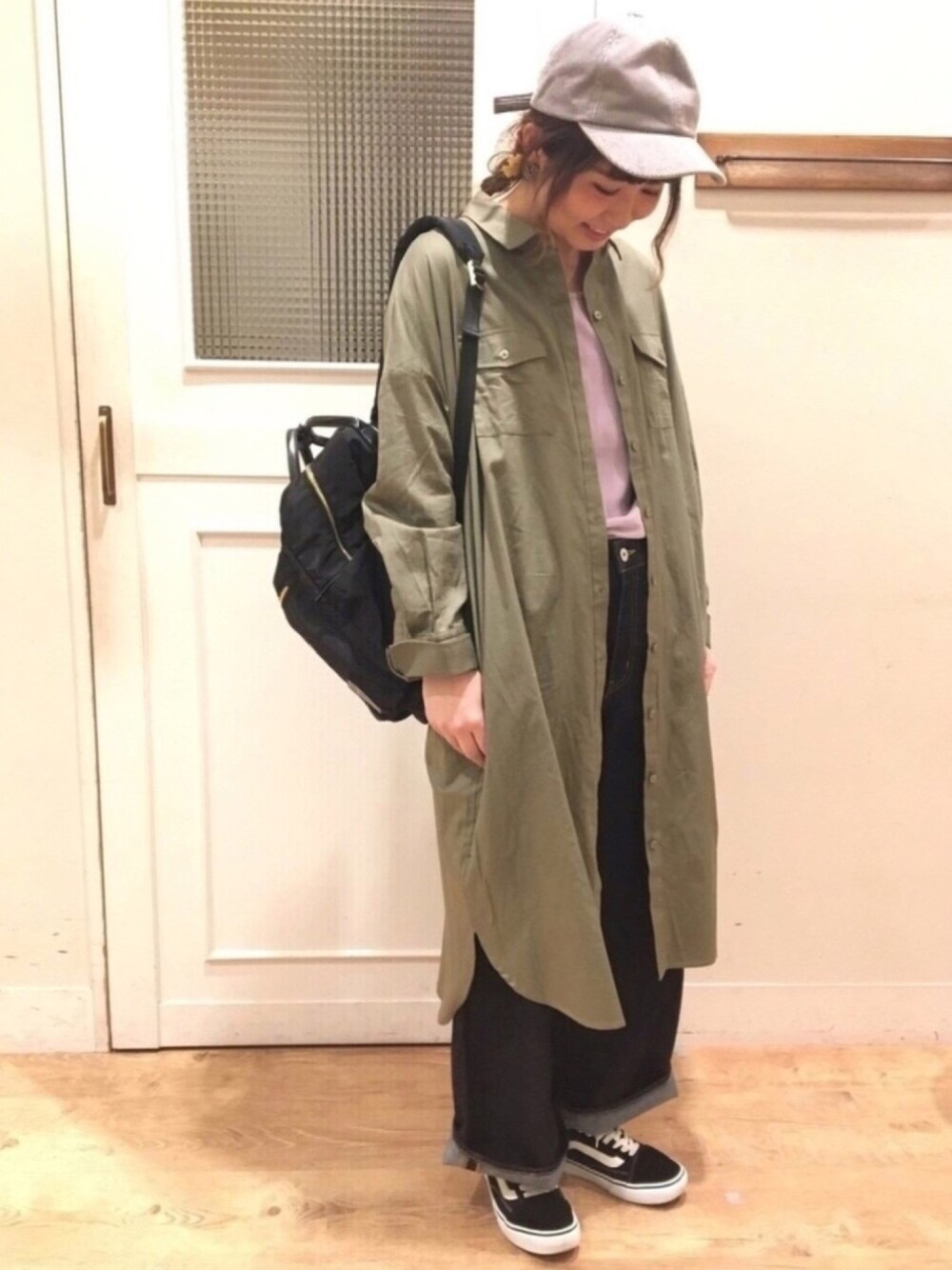 グリーン系のワンピース、パープル系のTシャツ/カットソー、ブルー系のデニムパンツを着用したレディースの春コーディネートの1枚目の写真
