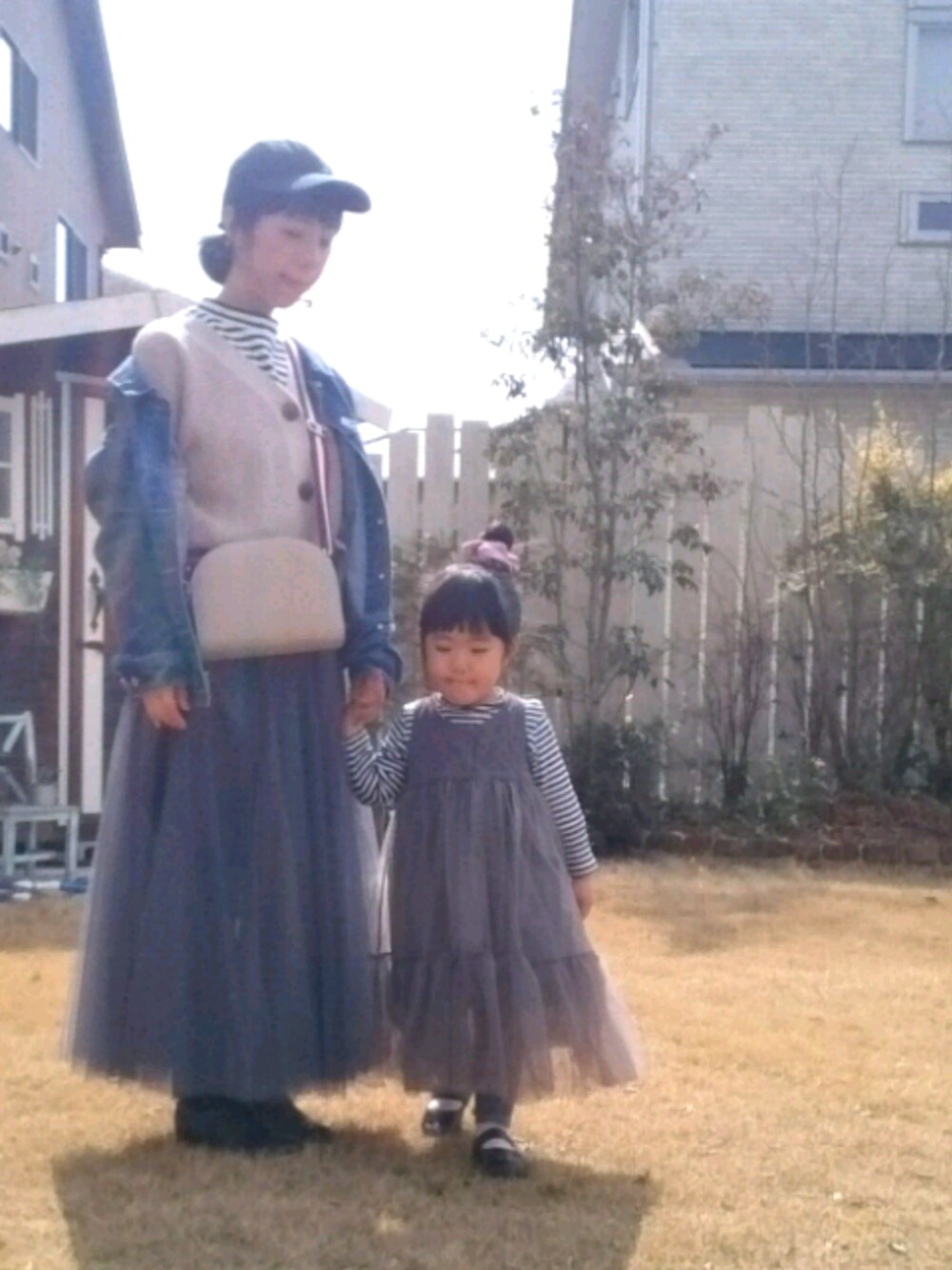 ベージュ系のカーディガン/ボレロ、ブルー系のデニムジャケット、グレー系のスカートを着用したレディースの春コーディネートの1枚目の写真