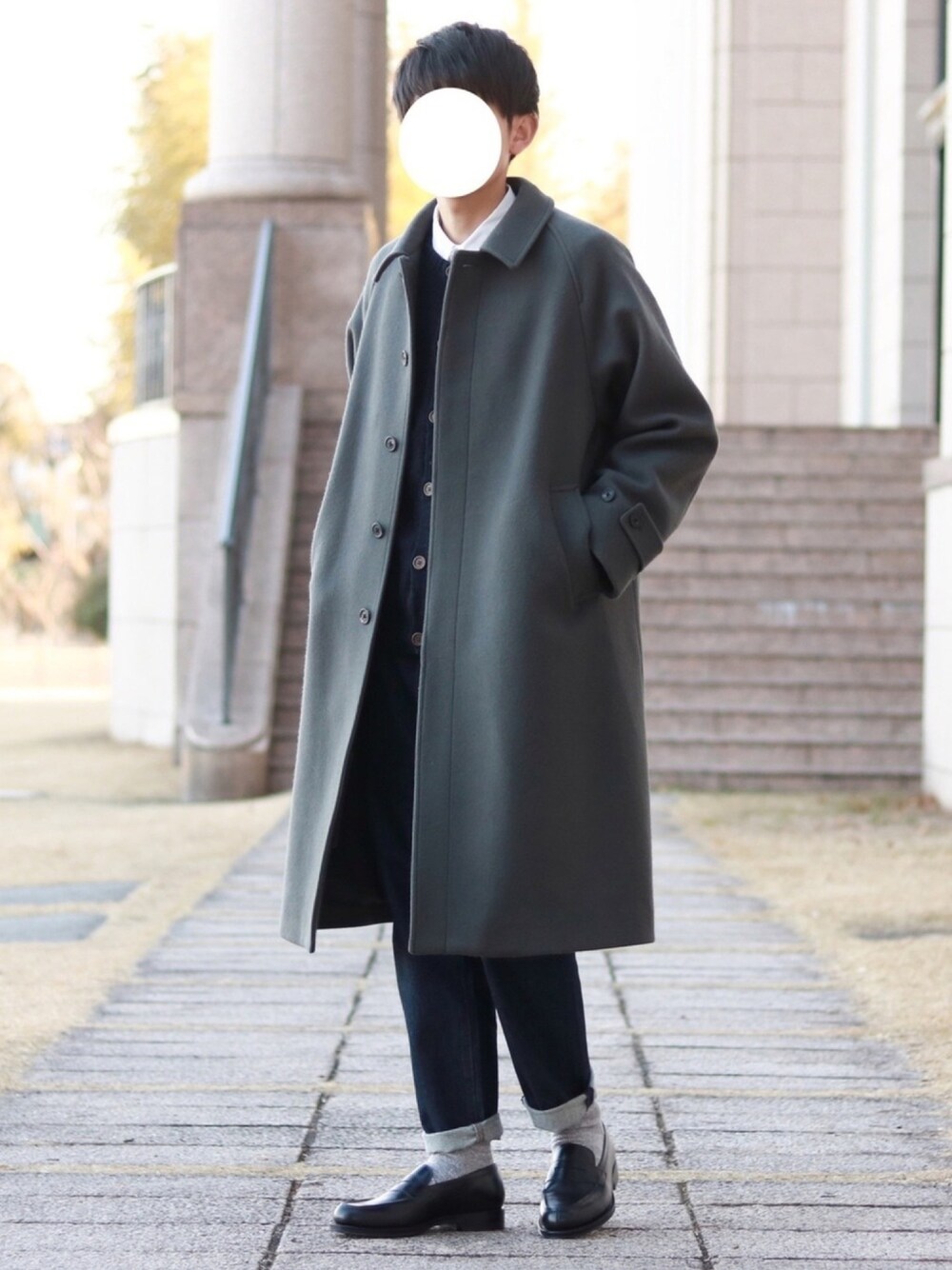 グレー系のステンカラーコート、ホワイト系のシャツ/ブラウス、ブルー系のニット/セーターを着用したメンズの冬コーディネートの1枚目の写真