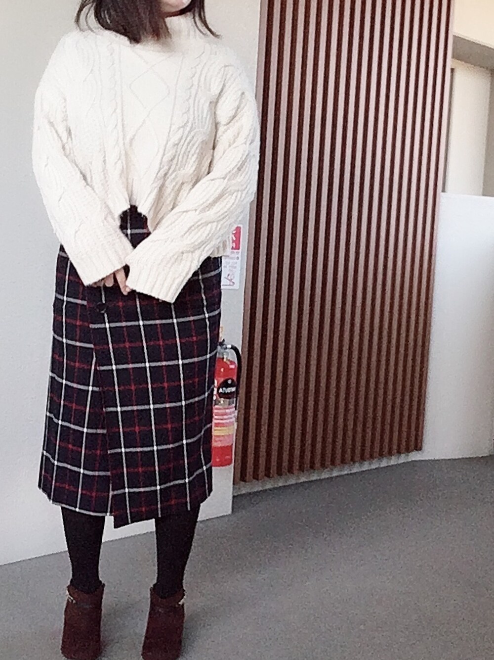 ホワイト系のニット/セーター、ブルー系のスカート、ブラウン系のブーツを着用したレディースの冬コーディネートの1枚目の写真