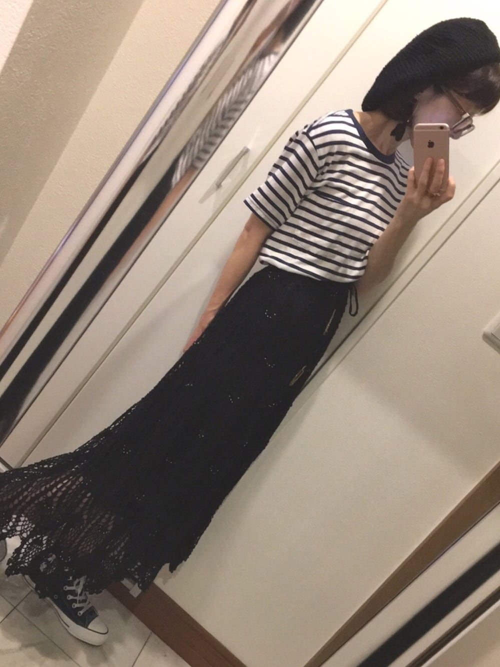 ブラック系のスカート、グリーン系のスニーカー、ホワイト系のTシャツ/カットソーを着用したレディースの夏コーディネートの1枚目の写真