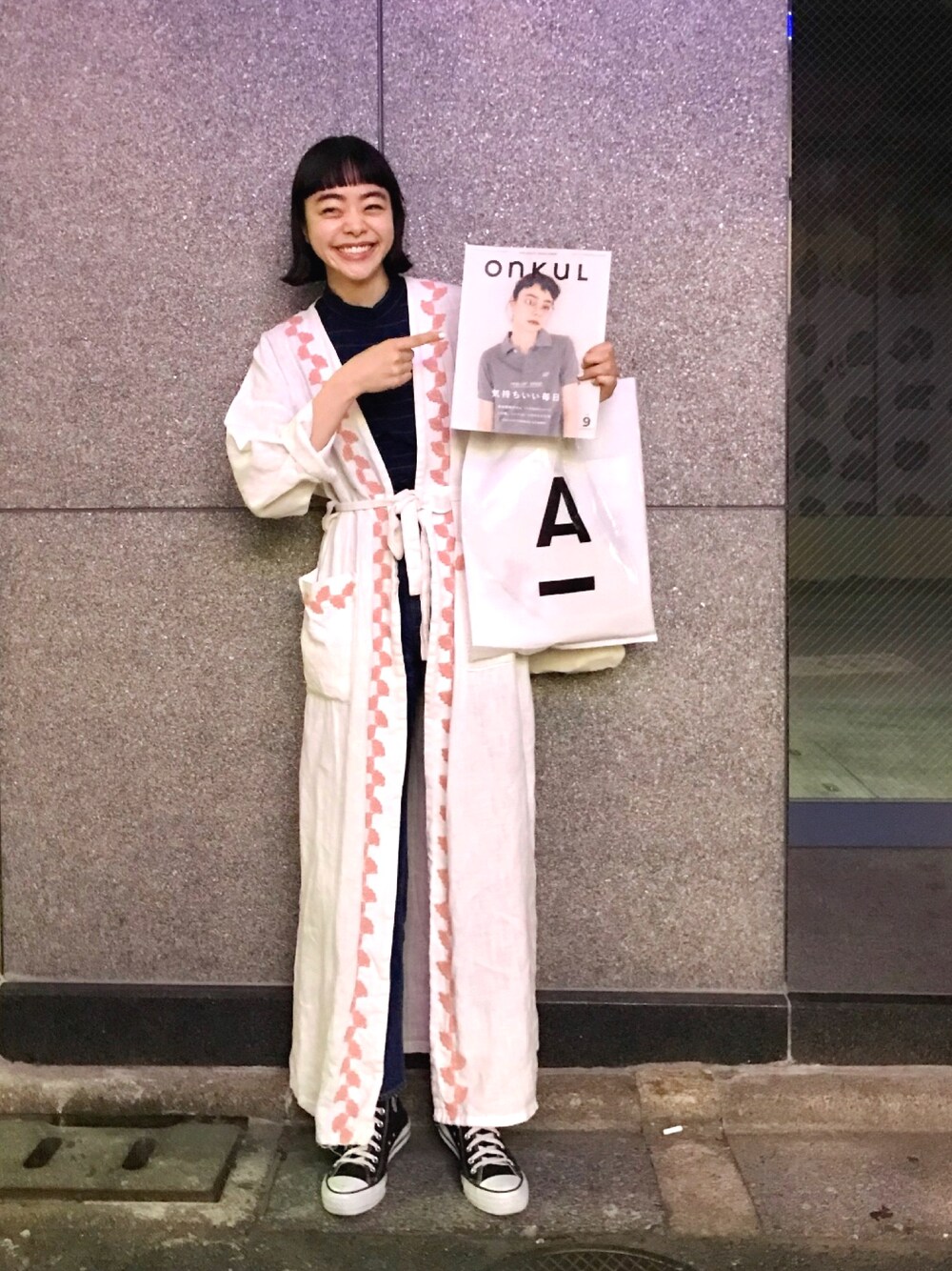グリーン系のTシャツ/カットソー、ブルー系のデニムパンツ、ブラック系のスニーカーを着用したレディースの春コーディネートの1枚目の写真