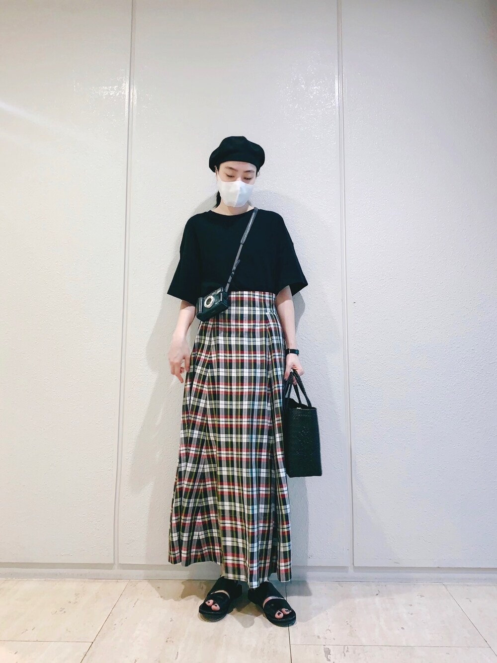 ブラック系のかごバッグ、ブラック系のTシャツ/カットソー、レッド系のスカートを着用したレディースの夏コーディネートの1枚目の写真