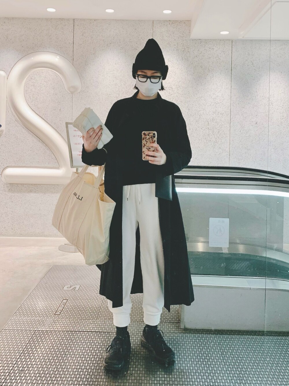 「大人カジュアル、モノトーン、白黒、ニット帽、白パンツ、スニーカー、シンプル、メンズライク、トートバッグ、パンツコーデ」｜「PUAL CE CINの【Kanocoさん着用】比翼ラグランコート（その他アウター、ブラック系）」を使った、Kanocoさん（レディース・170cm）の冬コーディネートの1枚目の写真