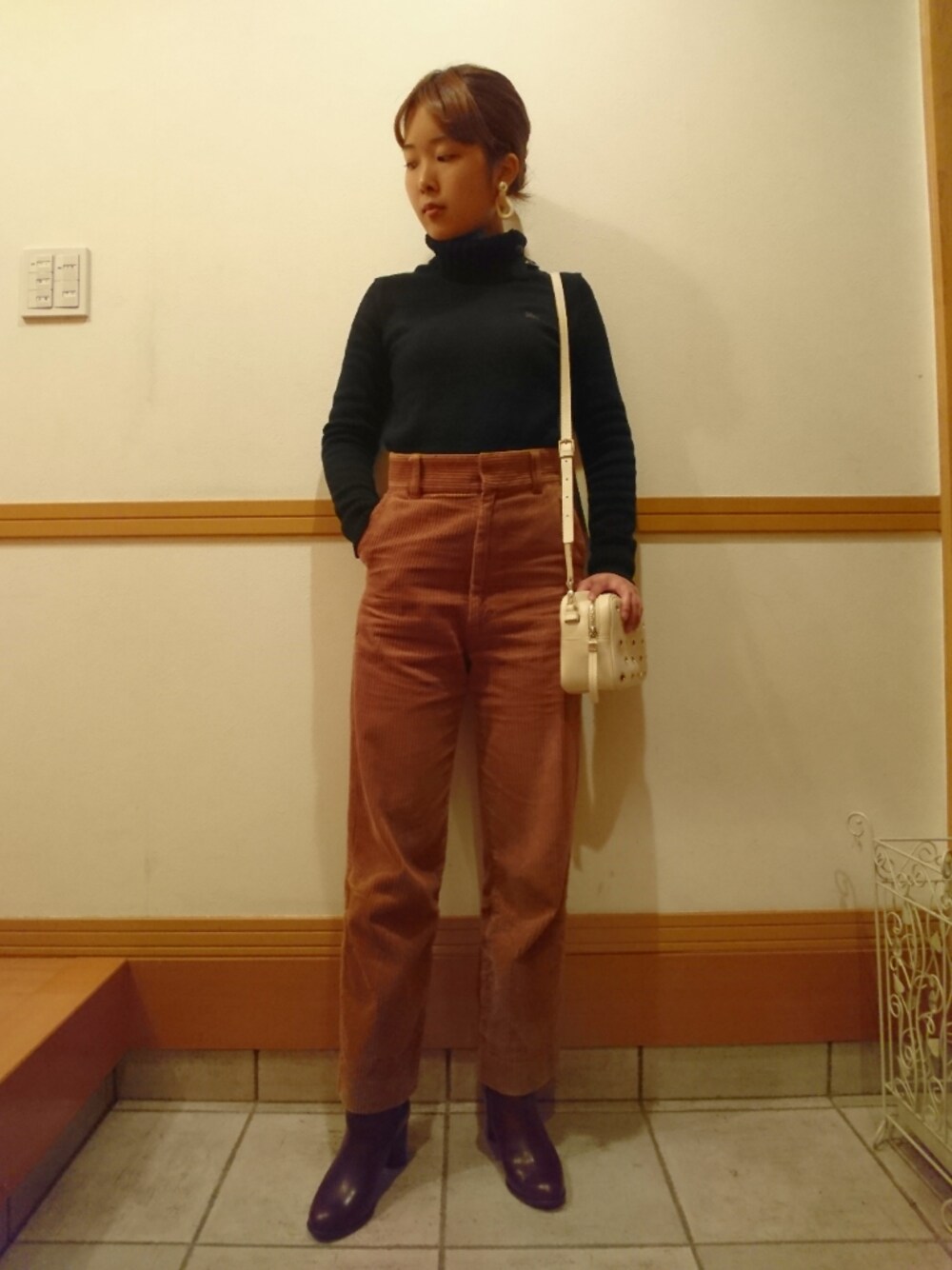 ブラック系のニット/セーター、ブラウン系のその他パンツ、レッド系のブーツを着用したレディースの秋コーディネートの1枚目の写真