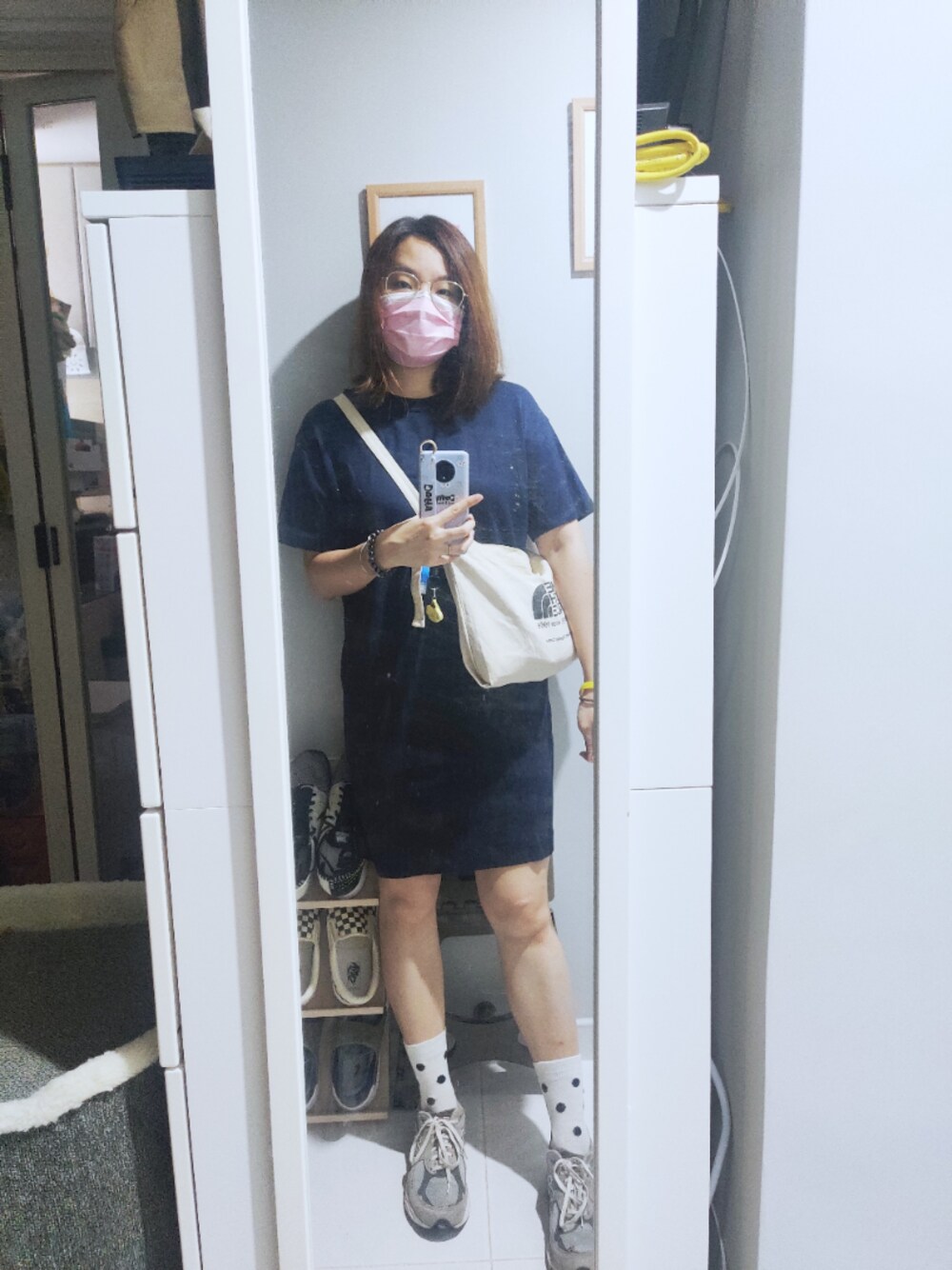 ブルー系のワンピース、ベージュ系のエコバッグ/サブバッグ、グレー系のスニーカーを着用したレディースの秋コーディネートの1枚目の写真