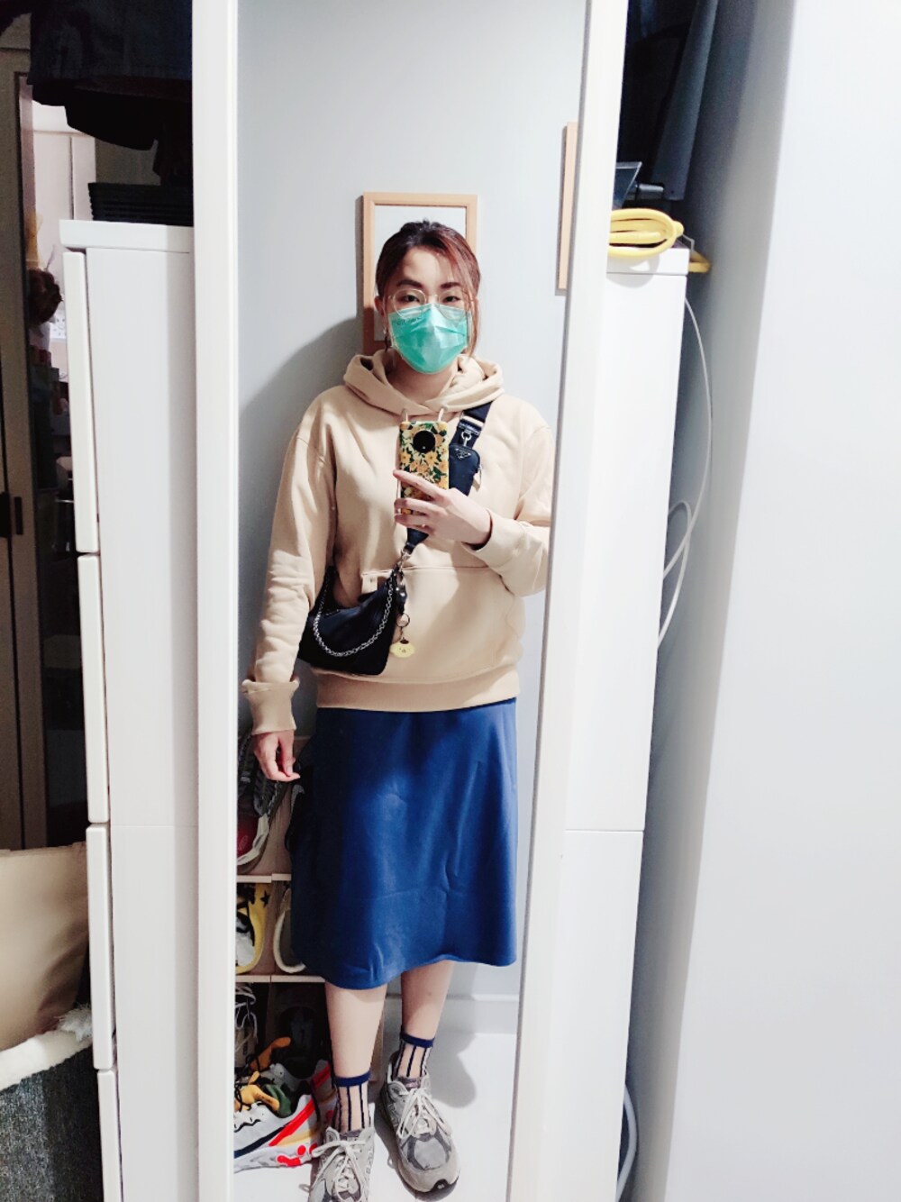 ブルー系のスカート、ベージュ系のその他トップス、ブラック系のショルダーバッグを着用したレディースの冬コーディネートの1枚目の写真