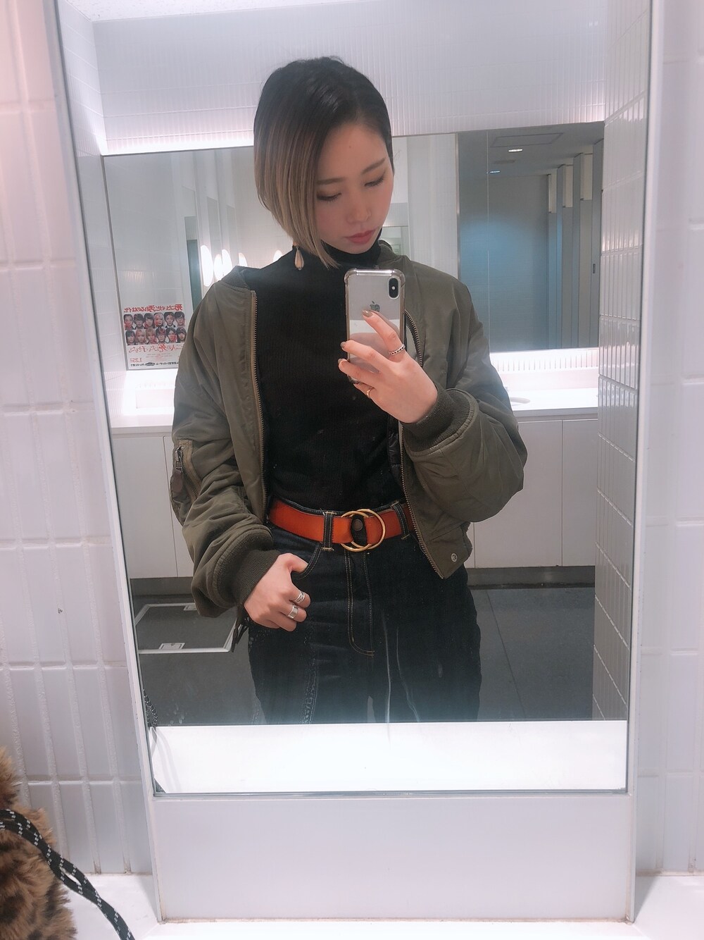 グリーン系のMA-1、ブラック系のニット/セーター、ブルー系のデニムパンツを着用したレディースの春コーディネートの1枚目の写真