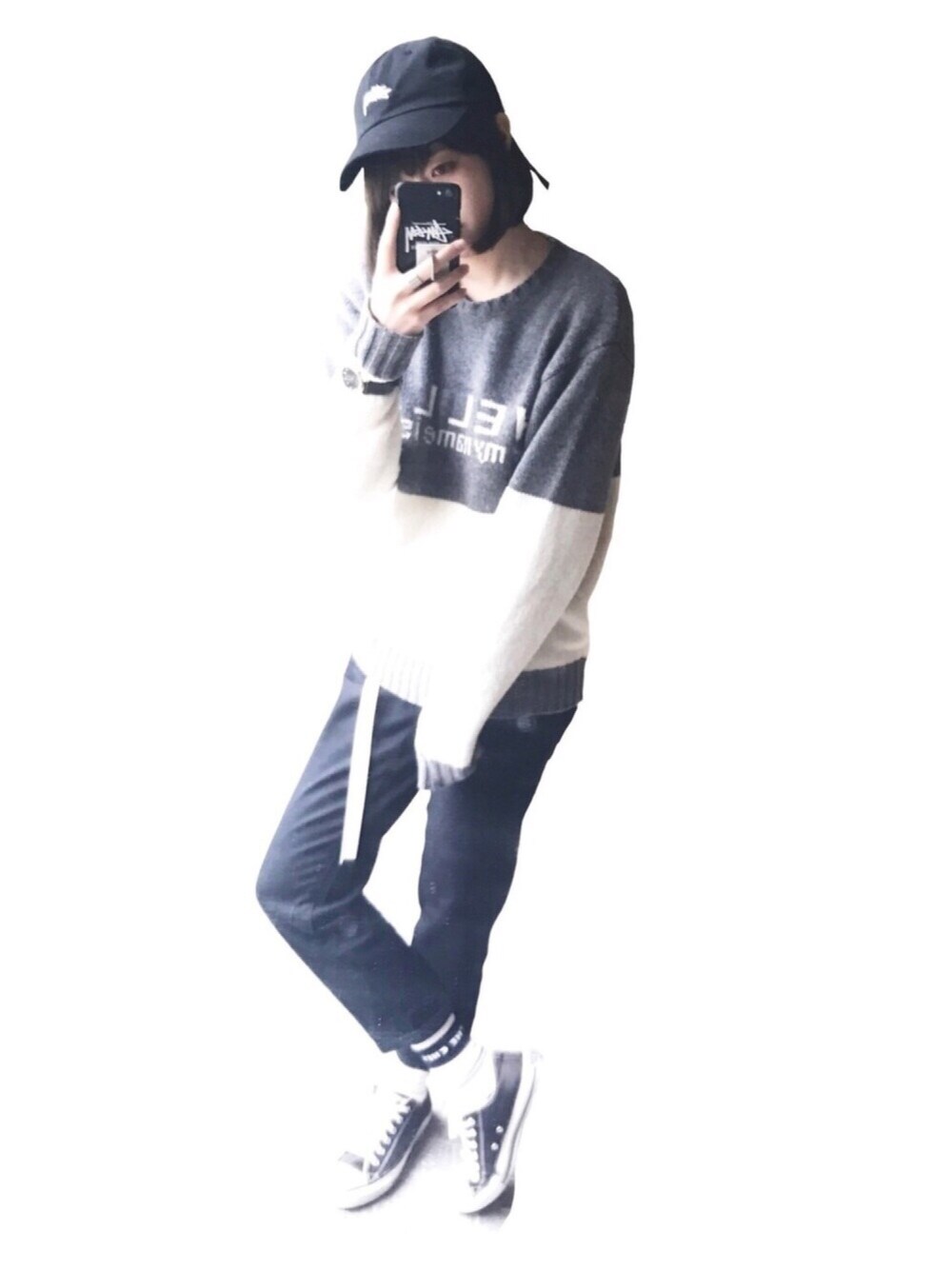 ブラック系のスニーカー、グレー系のニット/セーター、ブラック系のキャップを着用したレディースの春コーディネートの1枚目の写真