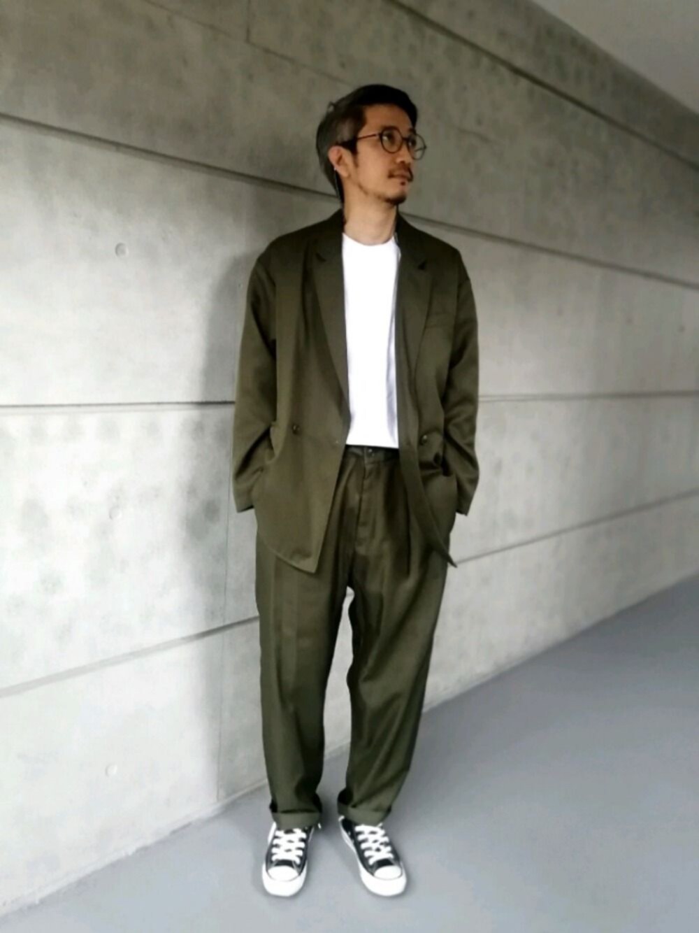 ブラック系のスニーカー、グリーン系のテーラードジャケットを着用したメンズの夏コーディネートの1枚目の写真
