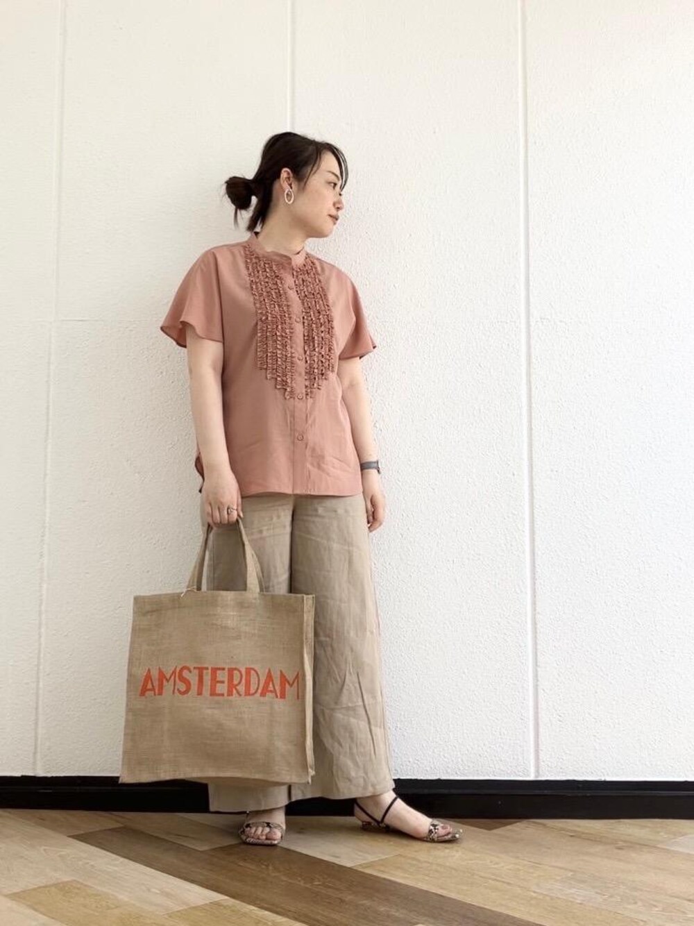 ピンク系のシャツ/ブラウス、ベージュ系のその他パンツ、オレンジ系のトートバッグを着用したレディースの春コーディネートの1枚目の写真