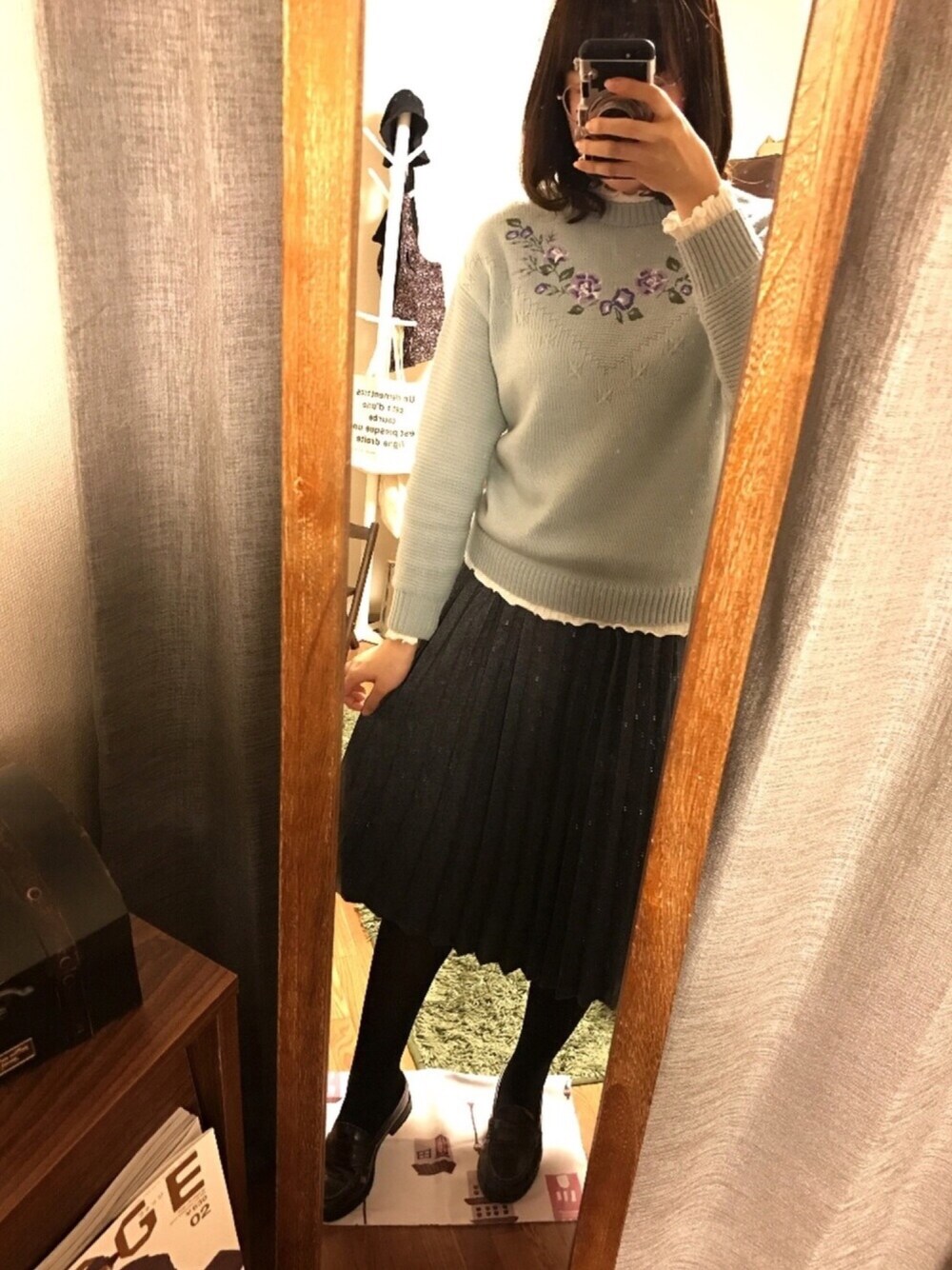 ホワイト系のTシャツ/カットソー、ブルー系のニット/セーター、グレー系のスカートを着用したレディースの冬コーディネートの1枚目の写真