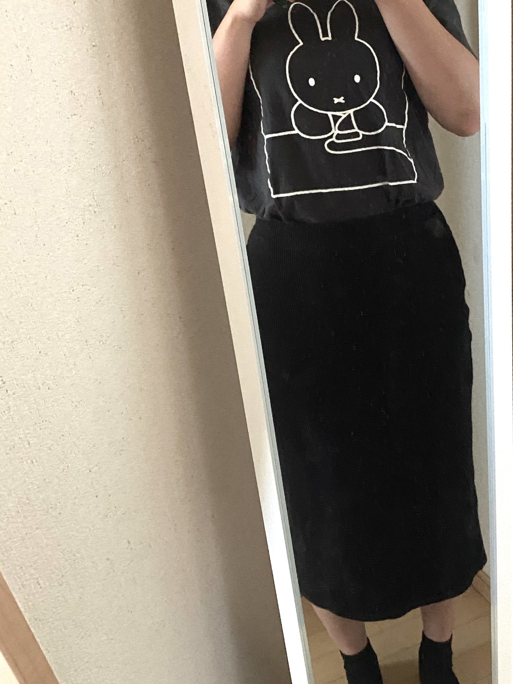 ブラック系のTシャツ/カットソー、ブラック系のスカート、ブラック系のローファーを着用したレディースの春コーディネートの1枚目の写真