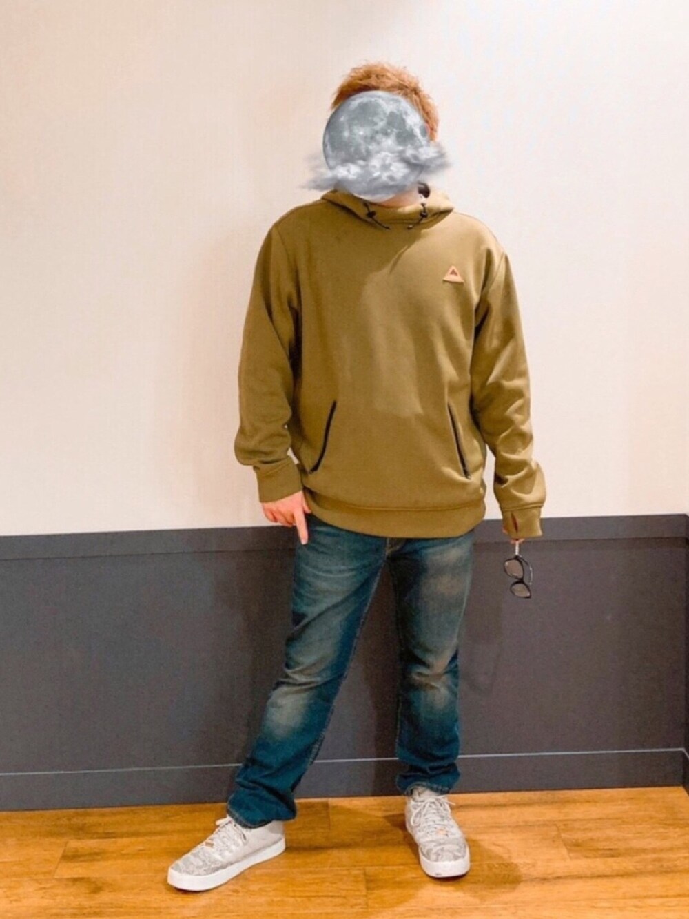 グリーン系のパーカー、ブルー系のデニムパンツ、グレー系のスニーカーを着用したメンズの秋コーディネートの1枚目の写真