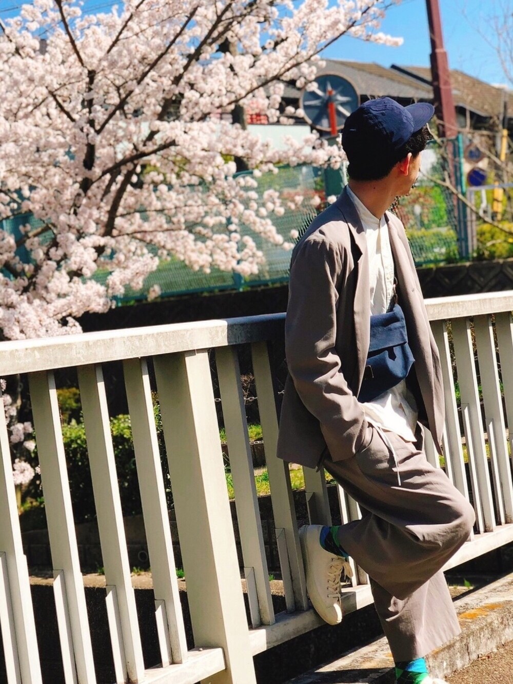 「春コーデ、大学生、セットアップ、グレー、キャップ、スニーカー、白スニーカー、ワイドパンツ、サコッシュ、桜」｜「Bshopのベースボールキャップ（キャップ、ブルー系）」を使った、山田和俊さん（メンズ・167cm）の春コーディネートの1枚目の写真