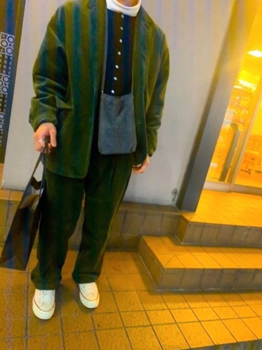 ブラック系のカーディガン/ボレロ、グリーン系のテーラードジャケット、グレー系のショルダーバッグを着用したメンズの冬コーディネートの1枚目の写真