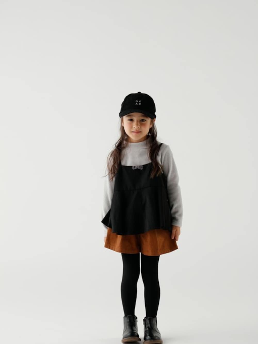 ブラック系のその他トップス、ブラック系のキャップを着用したキッズの秋コーディネートの1枚目の写真