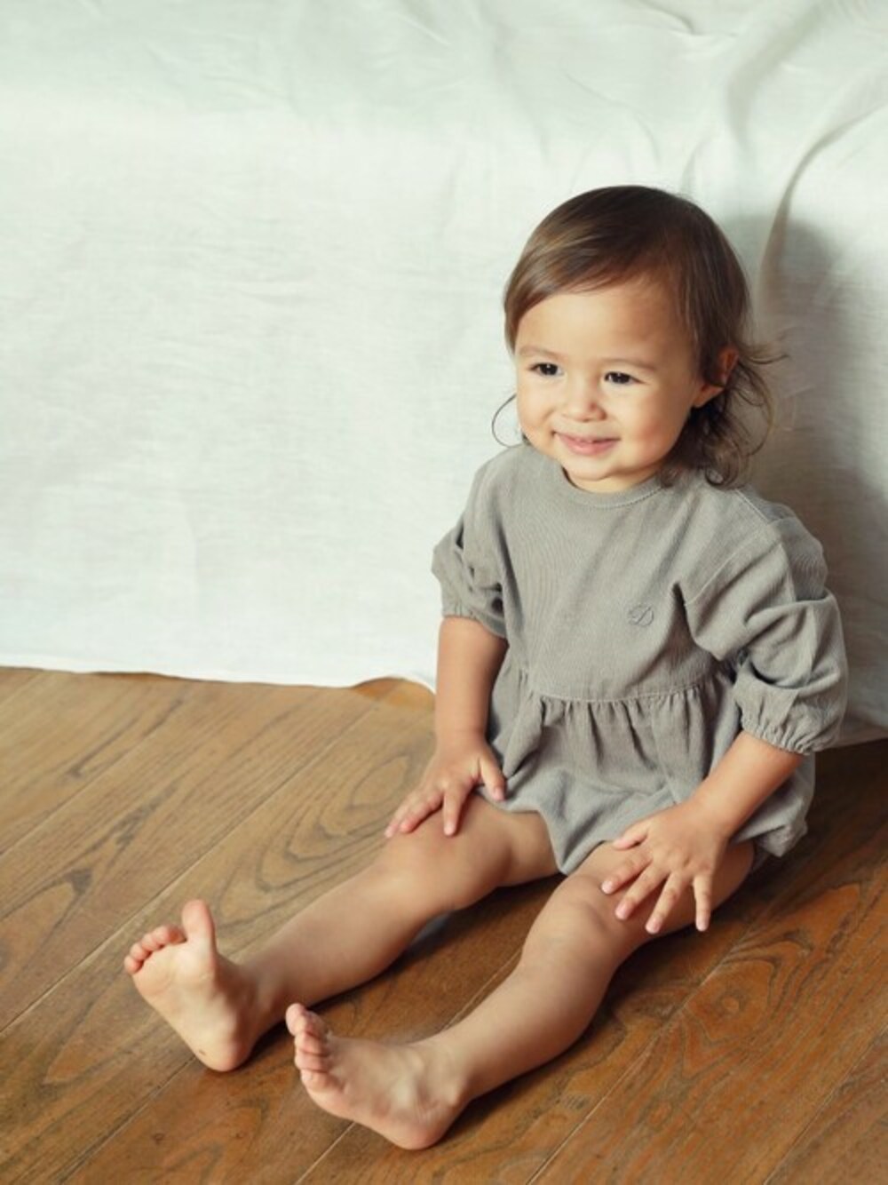 ベージュ系のロンパースを着用したキッズの秋コーディネートの1枚目の写真