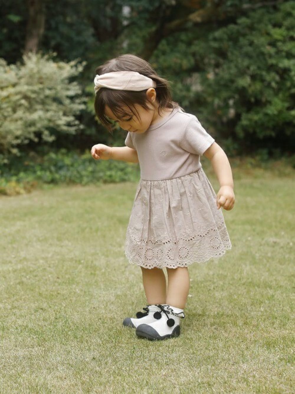 ホワイト系のその他シューズ、ピンク系のロンパース、ピンク系のヘアバンドを着用したキッズの冬コーディネートの1枚目の写真