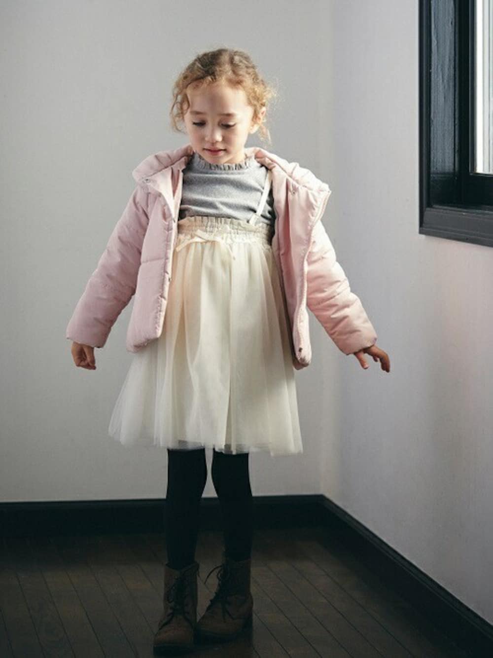 ピンク系のダウンジャケット/コート、グレー系のニット/セーター、ホワイト系のスカートを着用したキッズの秋コーディネートの1枚目の写真