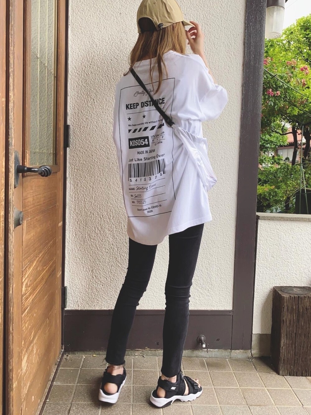 ホワイト系のTシャツ/カットソー、ホワイト系のショルダーバッグ、ブラック系のサンダルを着用したレディースの夏コーディネートの1枚目の写真