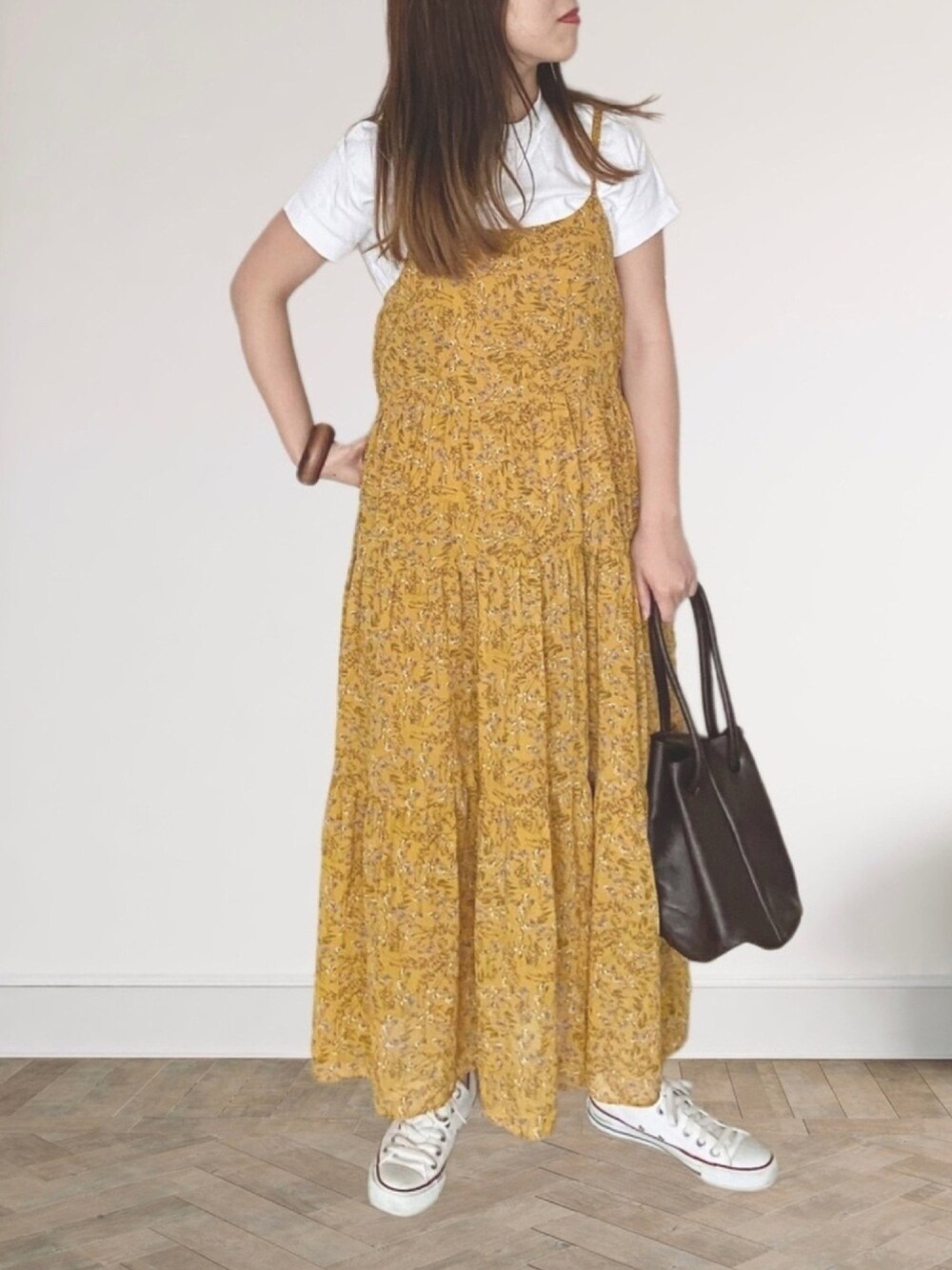 ホワイト系のTシャツ/カットソー、イエロー系のワンピース/ドレス、ブラウン系のハンドバッグを着用したレディースの春コーディネートの1枚目の写真