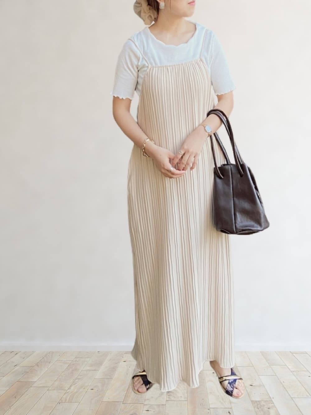 ベージュ系のワンピース、ブラウン系のハンドバッグ、ベージュ系のシュシュを着用したレディースの春コーディネートの1枚目の写真