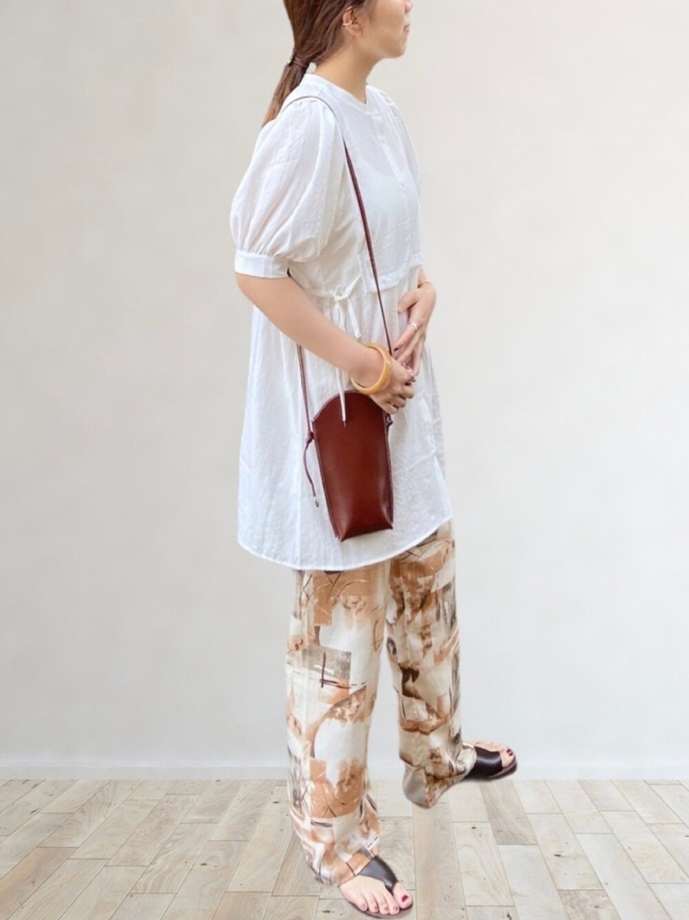 ホワイト系のシャツ/ブラウス、オレンジ系のその他パンツ、ブラウン系のサンダルを着用したレディースの夏コーディネートの1枚目の写真