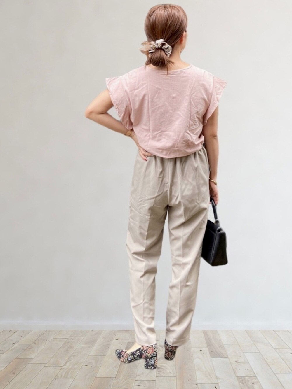 ピンク系のTシャツ/カットソー、ベージュ系のスラックス、その他のパンプスを着用したレディースの夏コーディネートの1枚目の写真