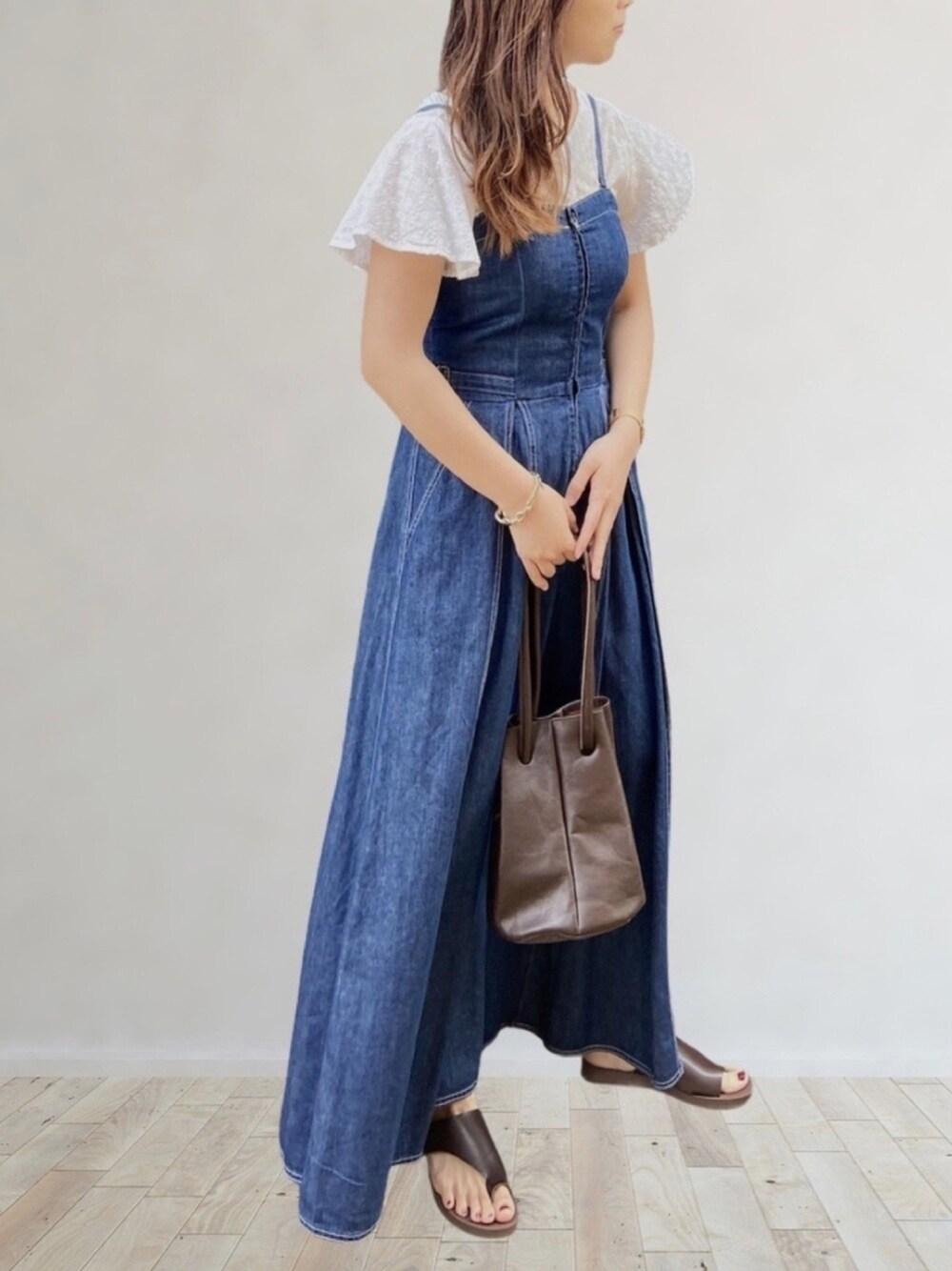 ブルー系のワンピース、ブラウン系のサンダル、ブラウン系のハンドバッグを着用したレディースの夏コーディネートの1枚目の写真