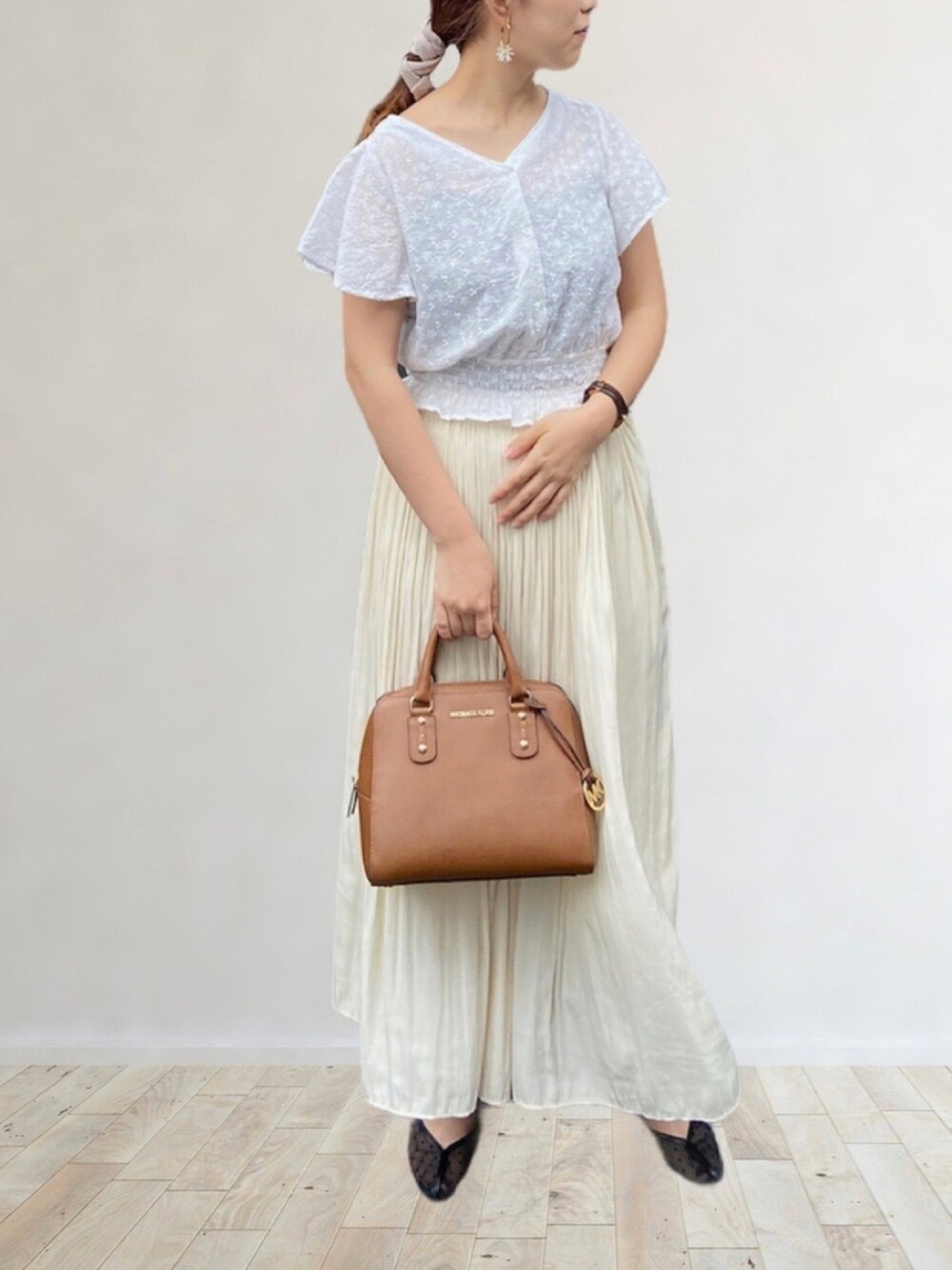 ホワイト系のシャツ/ブラウス、ホワイト系のスカート、ブラック系のパンプスを着用したレディースの夏コーディネートの1枚目の写真