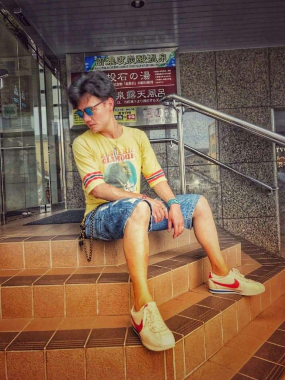 イエロー系のTシャツ/カットソー、ホワイト系のスニーカー、レッド系のブレスレットを着用したメンズの夏コーディネートの1枚目の写真