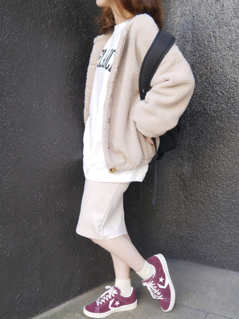 ベージュ系のノーカラージャケット、ホワイト系のスウェット、ブラック系のバックパック/リュックを着用したレディースの冬コーディネートの1枚目の写真