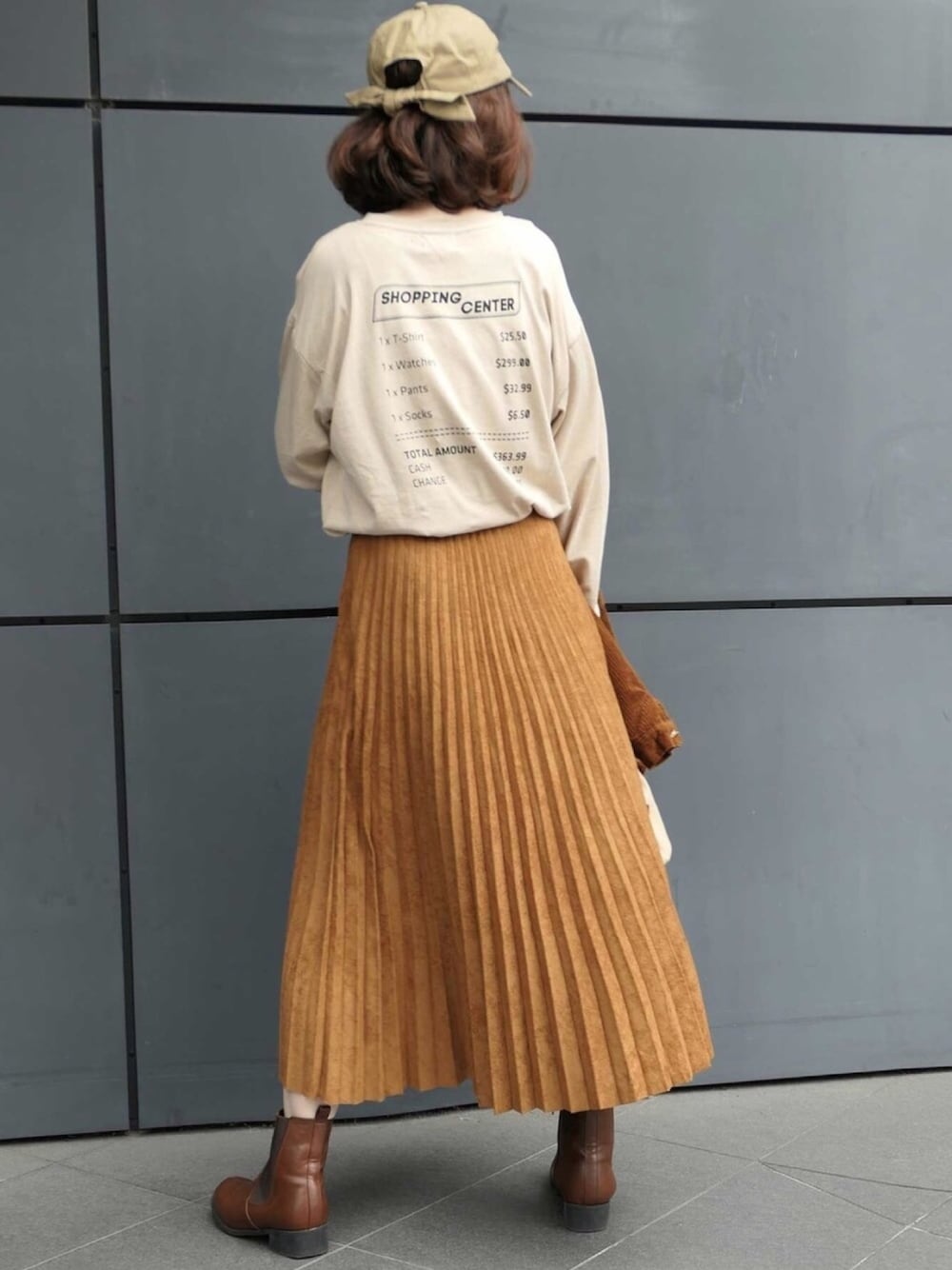 ベージュ系のTシャツ/カットソー、ブラウン系のスカート、ブラウン系のブルゾンを着用したレディースの秋コーディネートの1枚目の写真