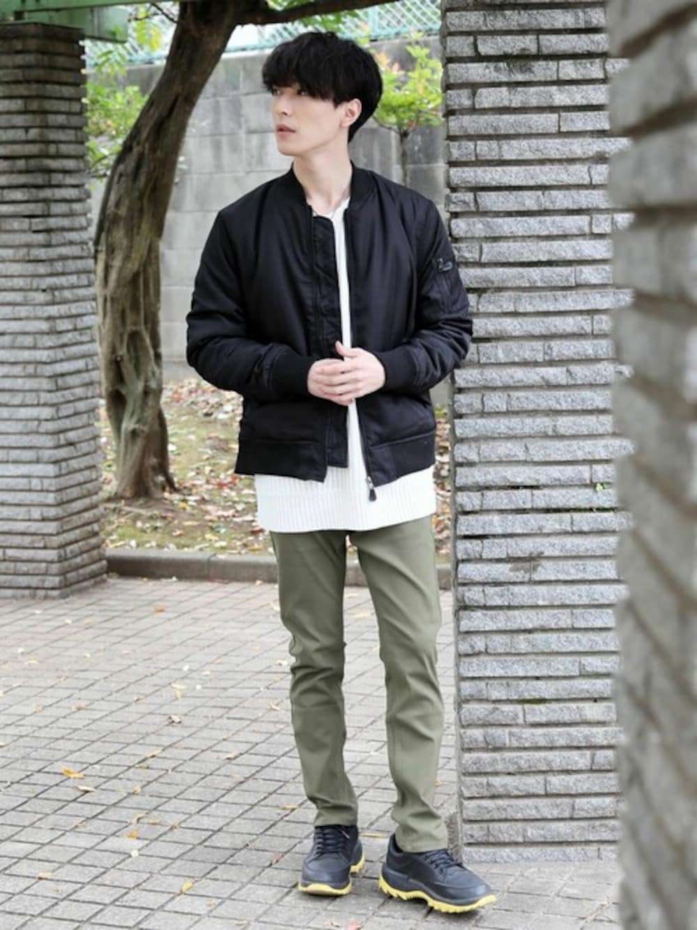 ブラック系のMA-1、グリーン系のチノパンツを着用したメンズの秋コーディネートの1枚目の写真