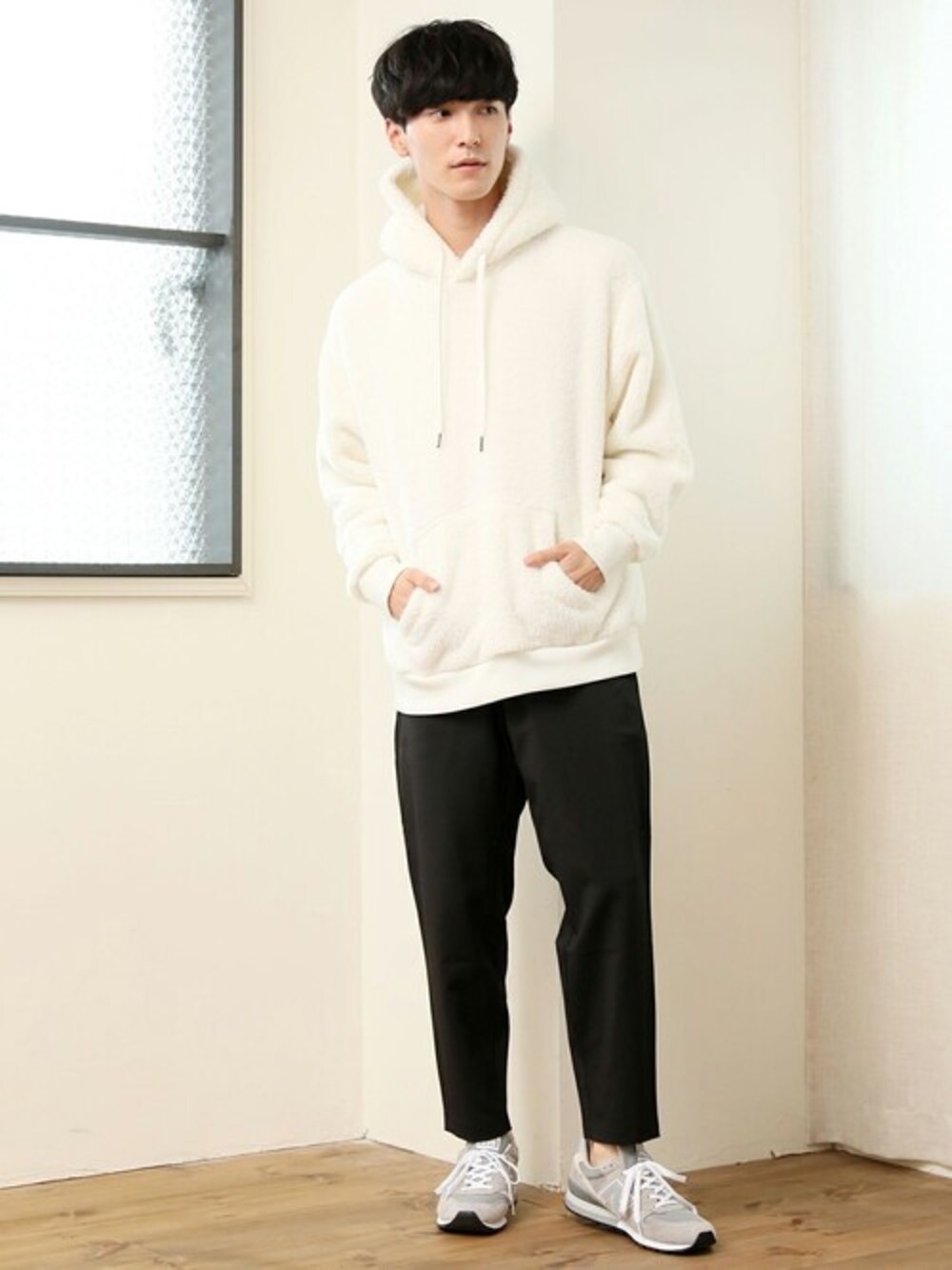 ホワイト系のパーカー、ブラック系のその他パンツを着用したメンズの冬コーディネートの1枚目の写真
