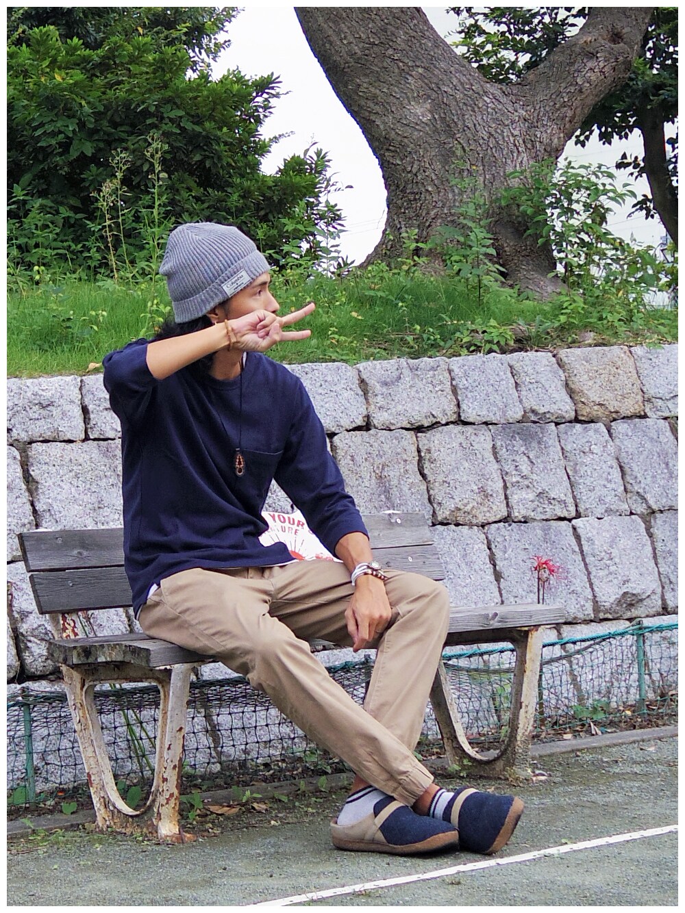 ホワイト系のタンクトップ、ベージュ系のチノパンツ、ブルー系のサンダルを着用したメンズの秋コーディネートの1枚目の写真