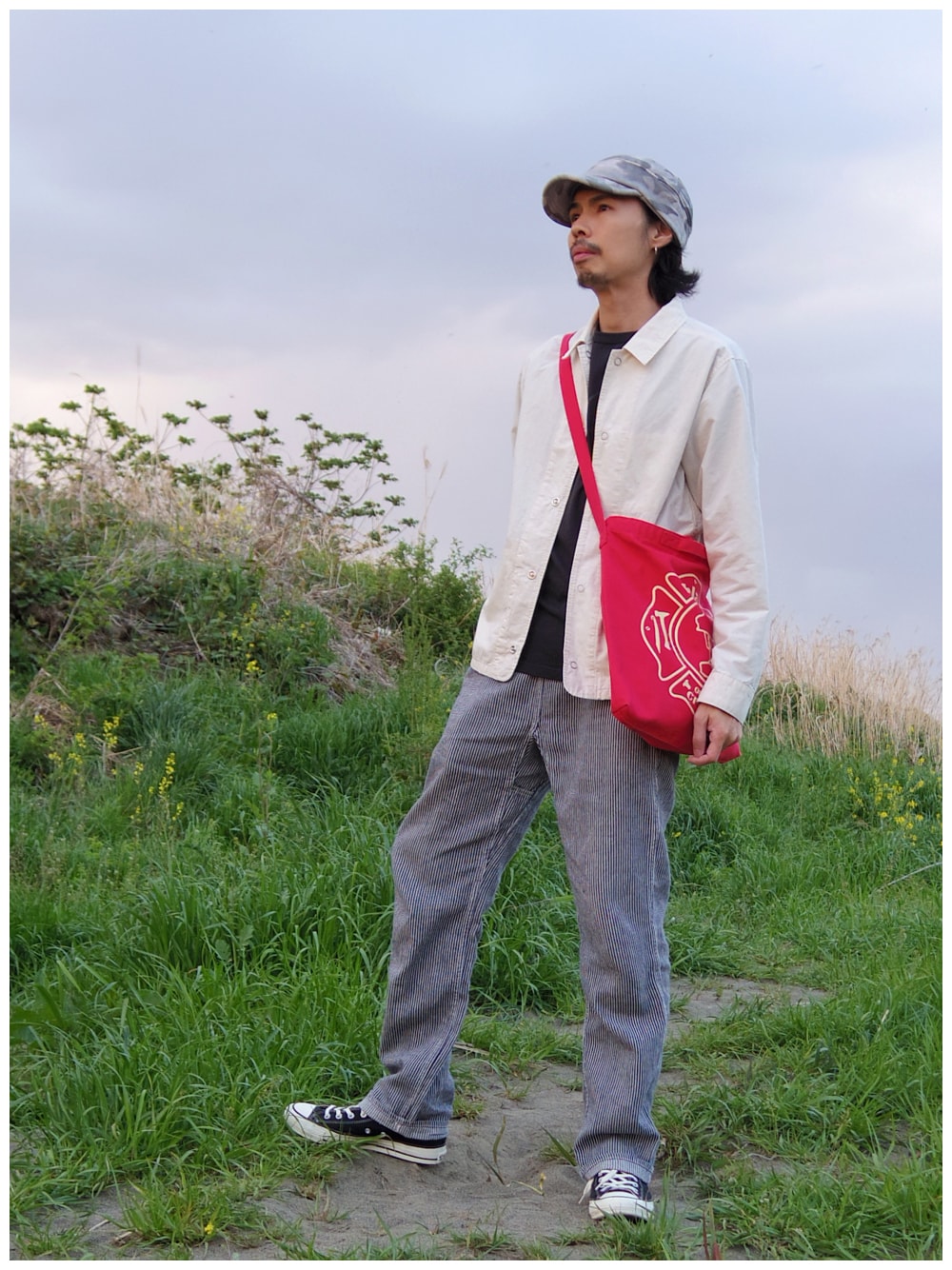 ホワイト系のブルゾン、レッド系のトートバッグ、その他のチノパンツを着用したメンズの春コーディネートの1枚目の写真