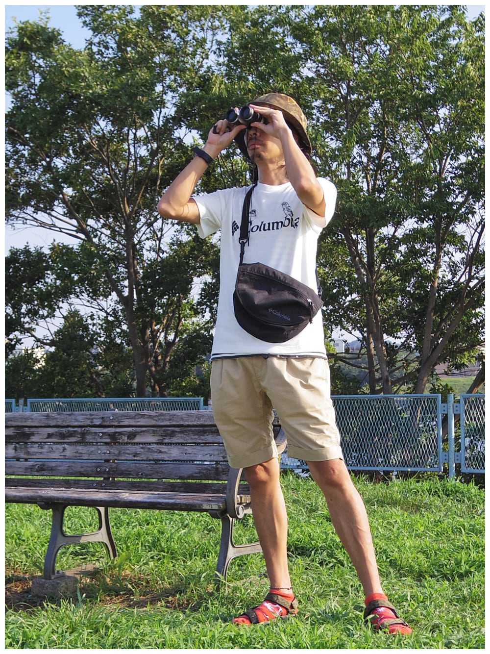 「ロゴT、カモフラ、ショルダーバッグ、アウトドアスタイル、ショートパンツ、ハーフパンツ、バケットハット、白Tシャツ、サンダルに靴下、COLUMBIA BLACK LABEL」｜「Columbiaのリトルブラックウォータースプリングスバケット（ハット、その他）」を使った、つちぽんさん（メンズ・177cm）の夏コーディネートの1枚目の写真