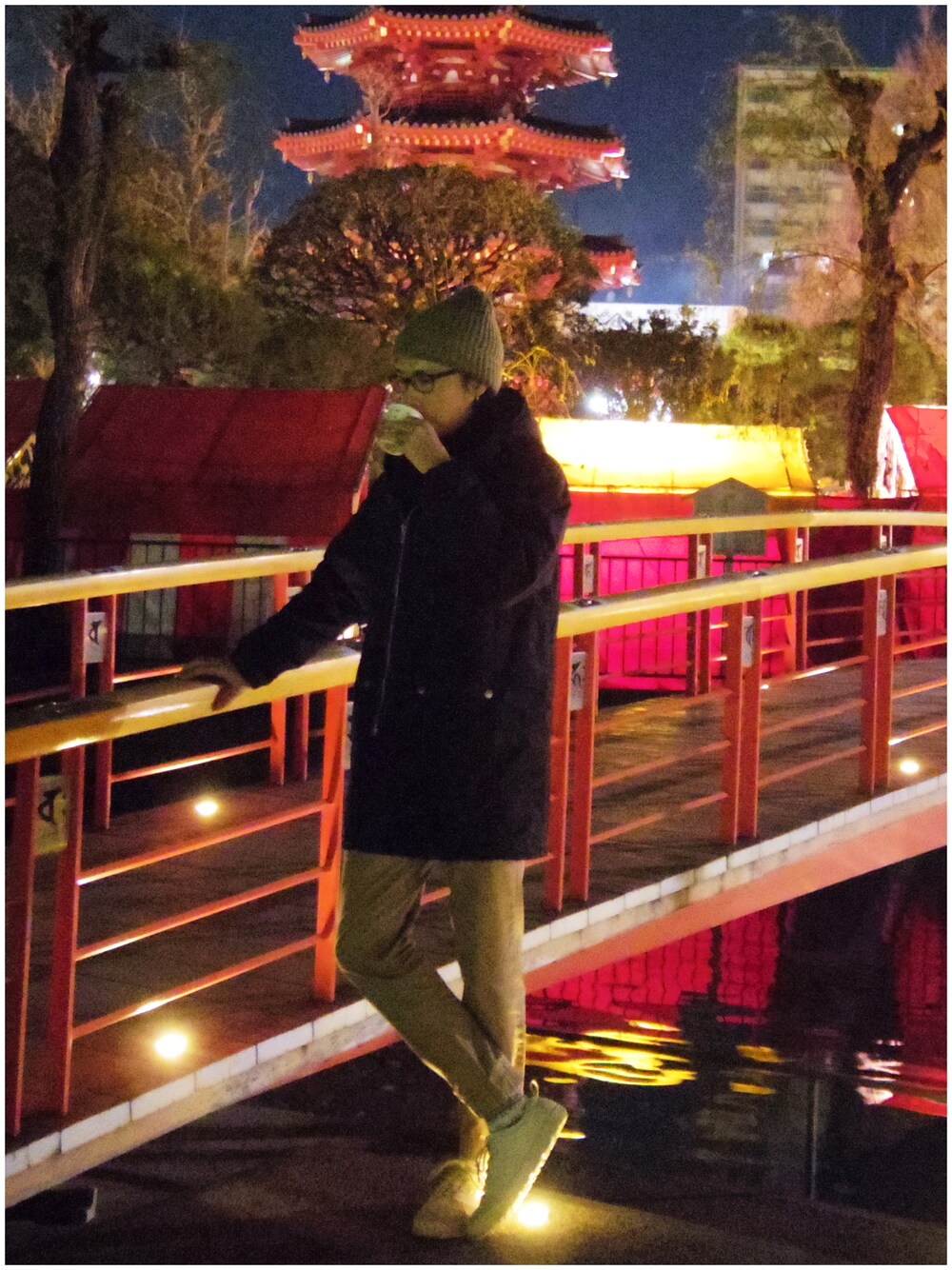 ブラック系のモッズコート、ベージュ系のチノパンツ、グレー系のスニーカーを着用したメンズの冬コーディネートの1枚目の写真