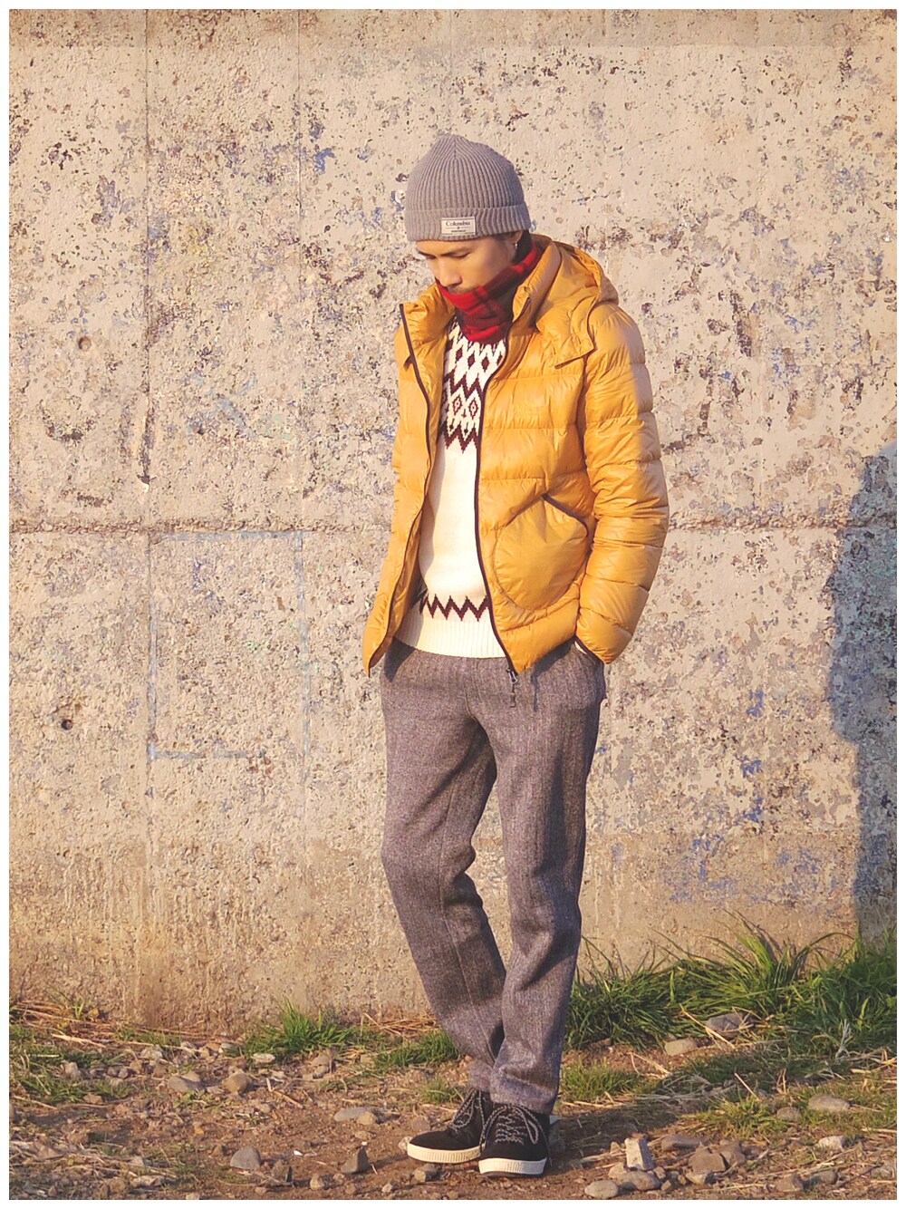 イエロー系のダウンジャケット/コート、ホワイト系のニット/セーター、ブラック系のスウェットパンツを着用したメンズの冬コーディネートの1枚目の写真