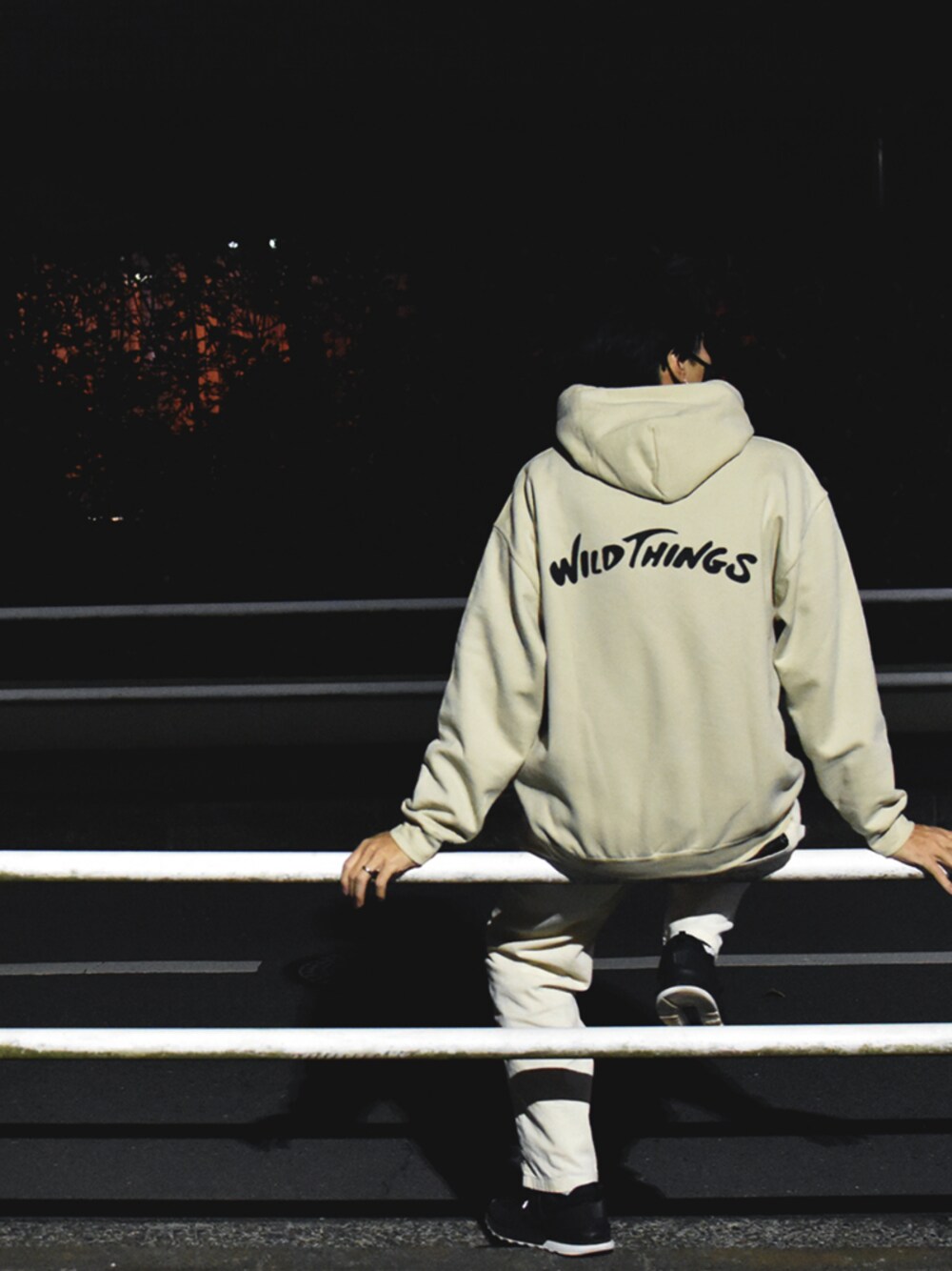 ベージュ系のパーカー、ブラック系のスニーカーを着用したメンズの春コーディネートの1枚目の写真