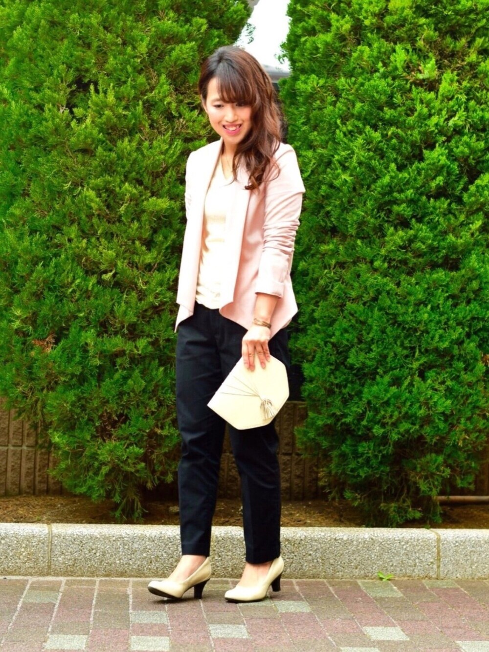 ピンク系のノーカラージャケット、ホワイト系のニット/セーター、ホワイト系のショルダーバッグを着用したレディースの春コーディネートの1枚目の写真