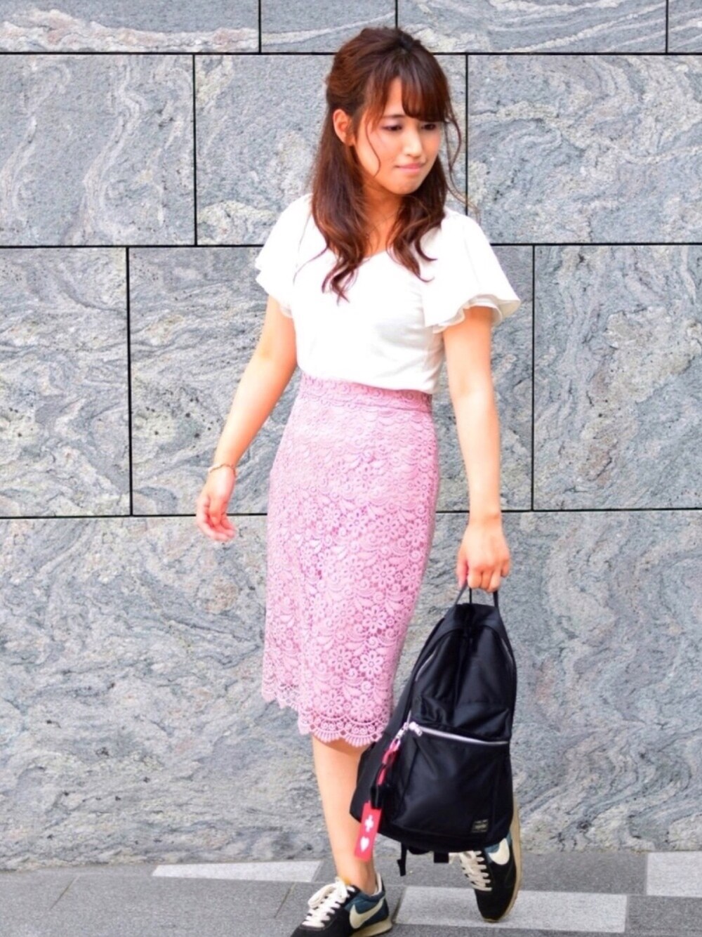 ホワイト系のTシャツ/カットソー、ピンク系のスカート、ブラック系のバックパック/リュックを着用したレディースの夏コーディネートの1枚目の写真