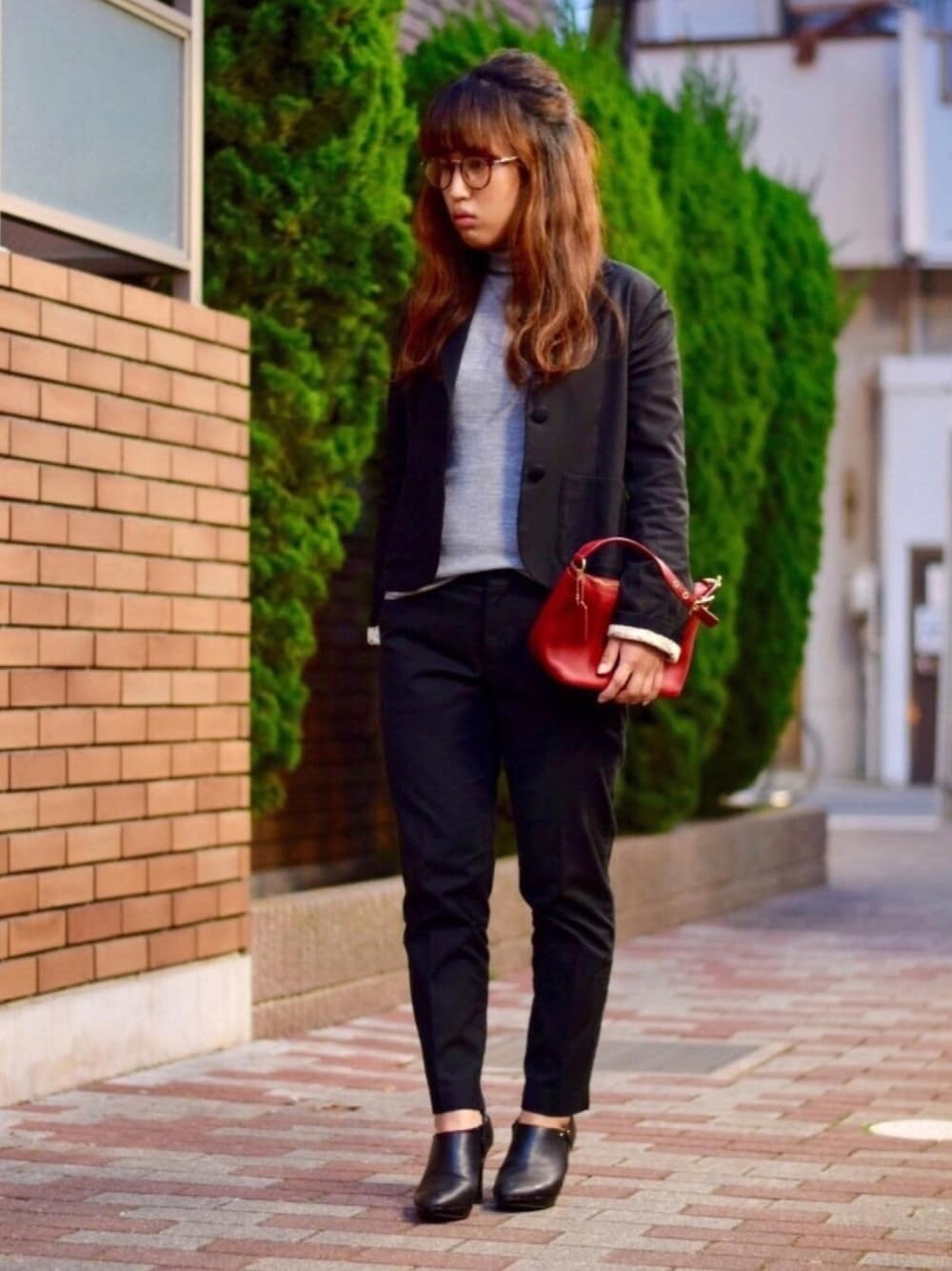 グレー系のニット/セーター、ブラック系のテーラードジャケット、ブラック系のその他パンツを着用したレディースの秋コーディネートの1枚目の写真