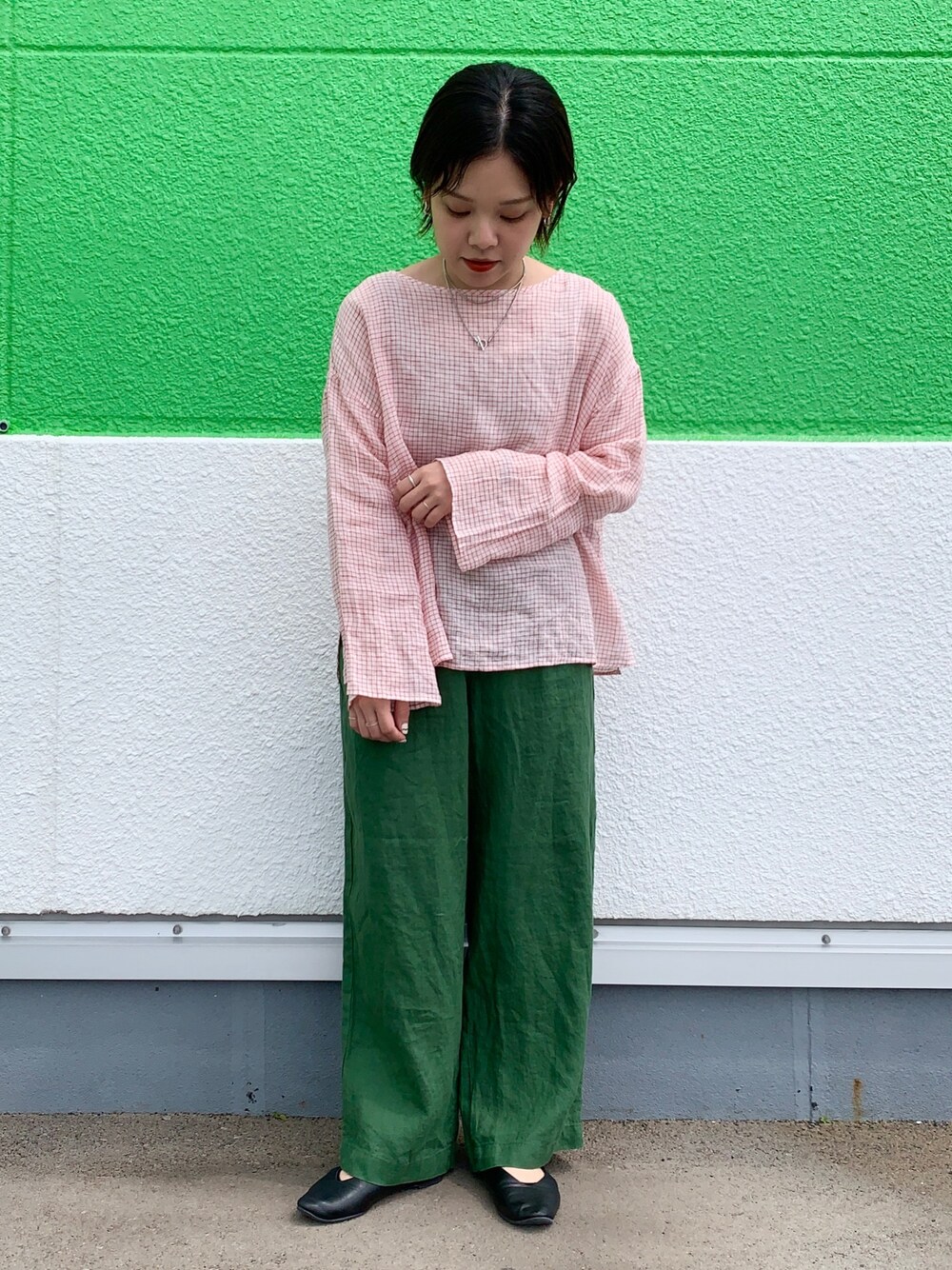 レッド系のトップス、グリーン系のその他パンツ、ブラック系のパンプスを着用したレディースの春コーディネートの1枚目の写真