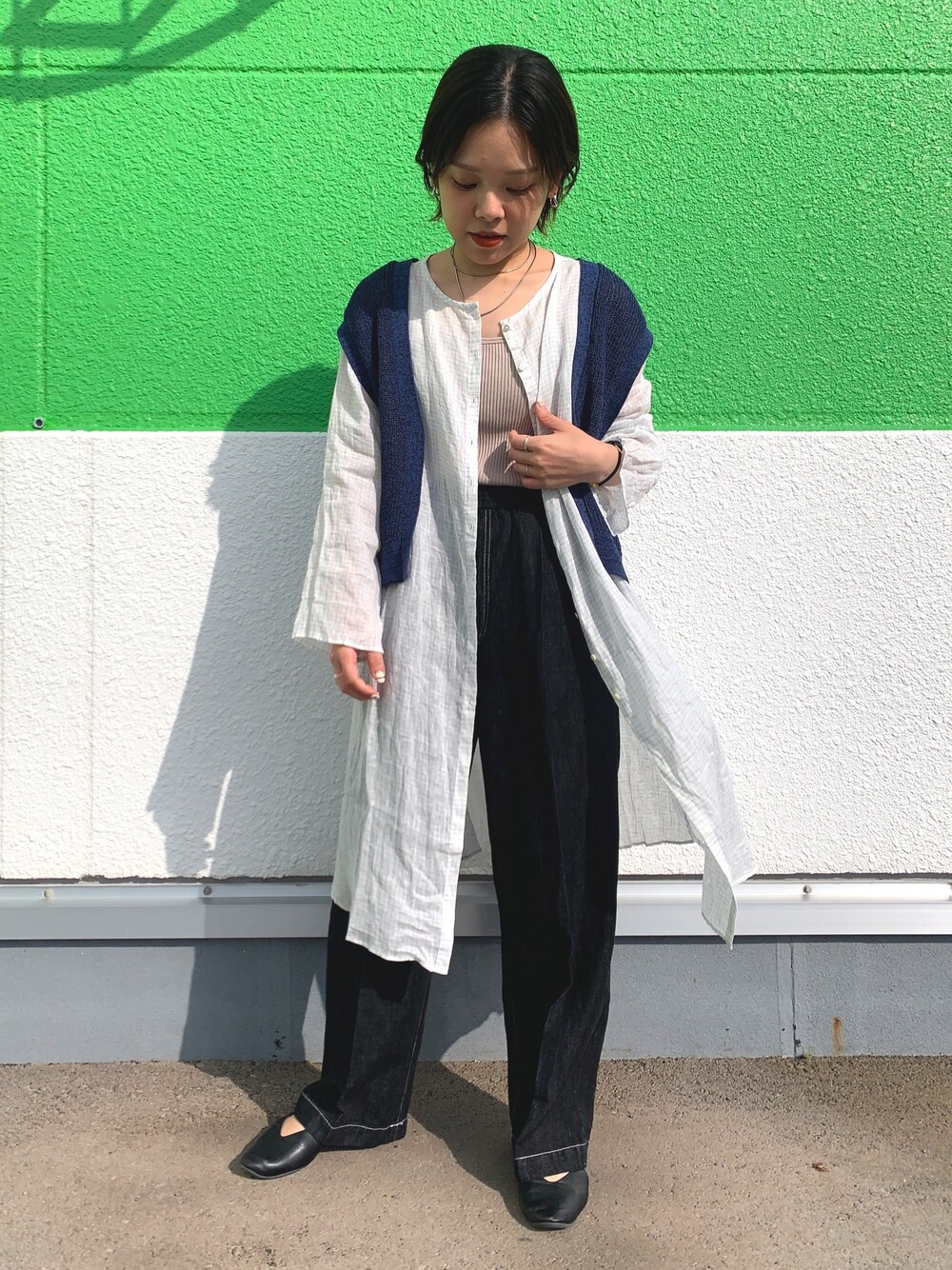 ブルー系のベスト、ブルー系のシャツ/ブラウス、ブラック系のデニムパンツを着用したレディースの春コーディネートの1枚目の写真