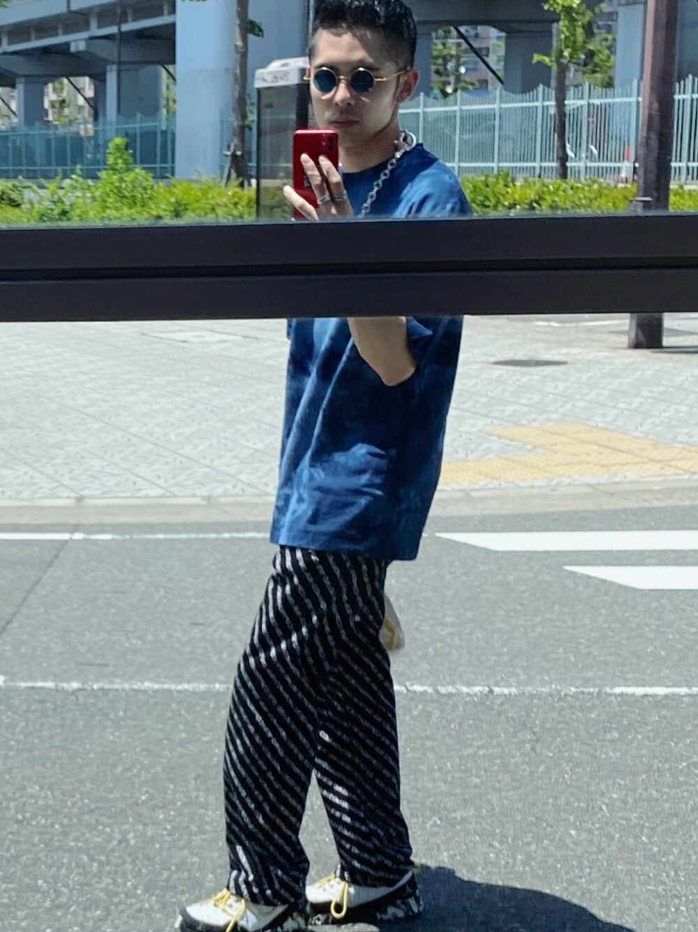 ブルー系のTシャツ/カットソー、ブラック系のデニムパンツ、ブルー系のサングラスを着用したメンズの夏コーディネートの1枚目の写真