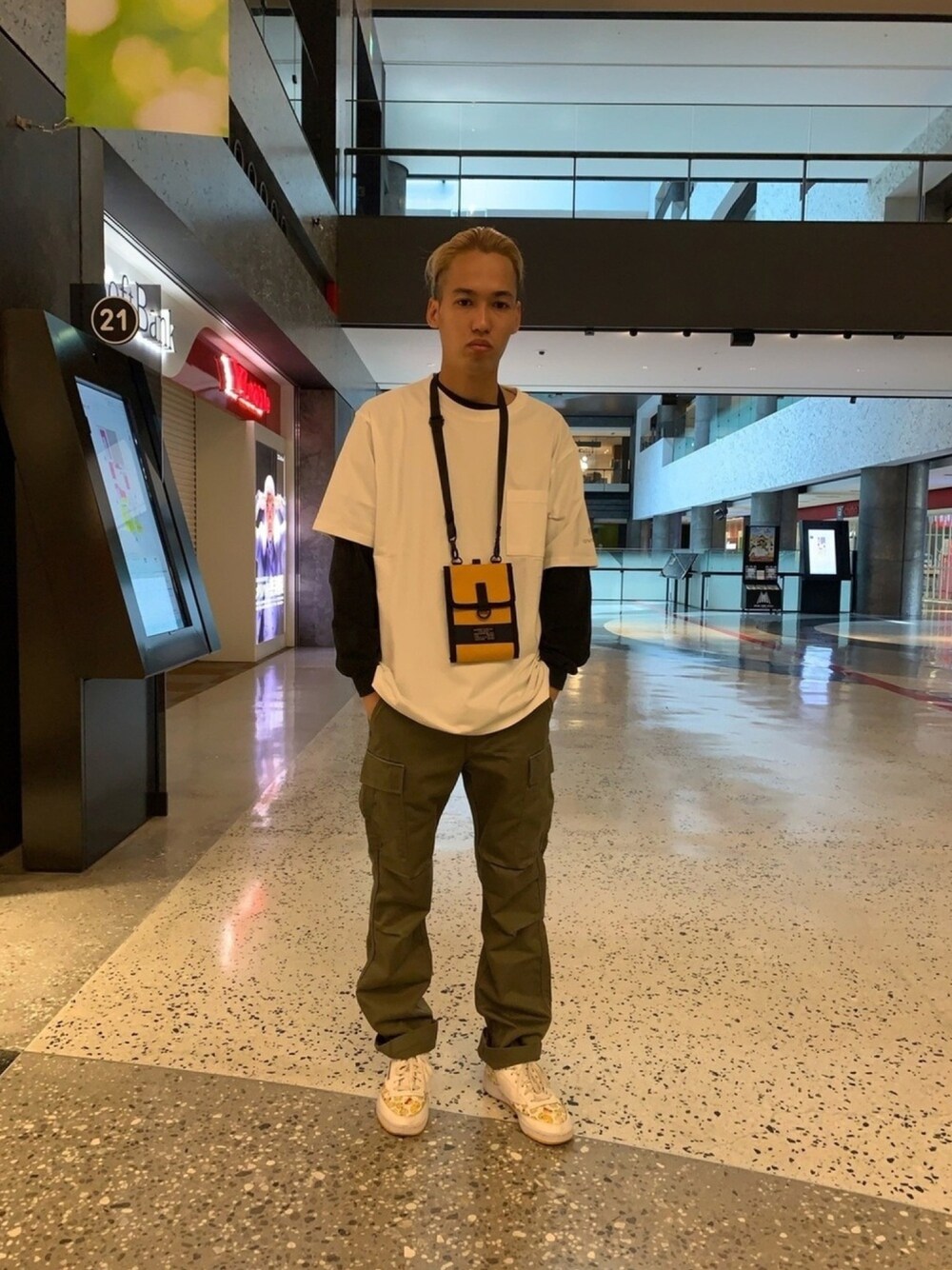 ホワイト系のTシャツ/カットソー、イエロー系のショルダーバッグ、グリーン系のカーゴパンツを着用したメンズの春コーディネートの1枚目の写真